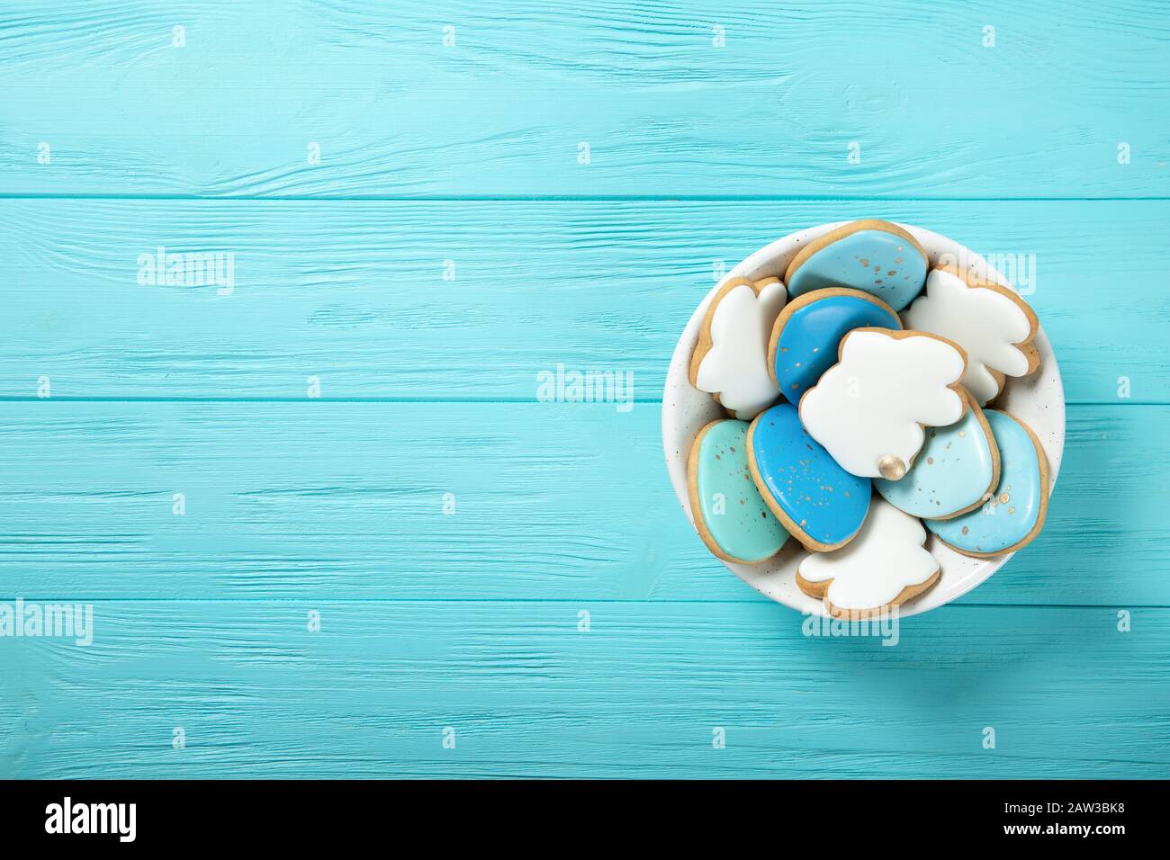 Easter cookies in a plate on a blue background. Easter eggs. Easter bunnies. Place for text. View from above Stock Photo