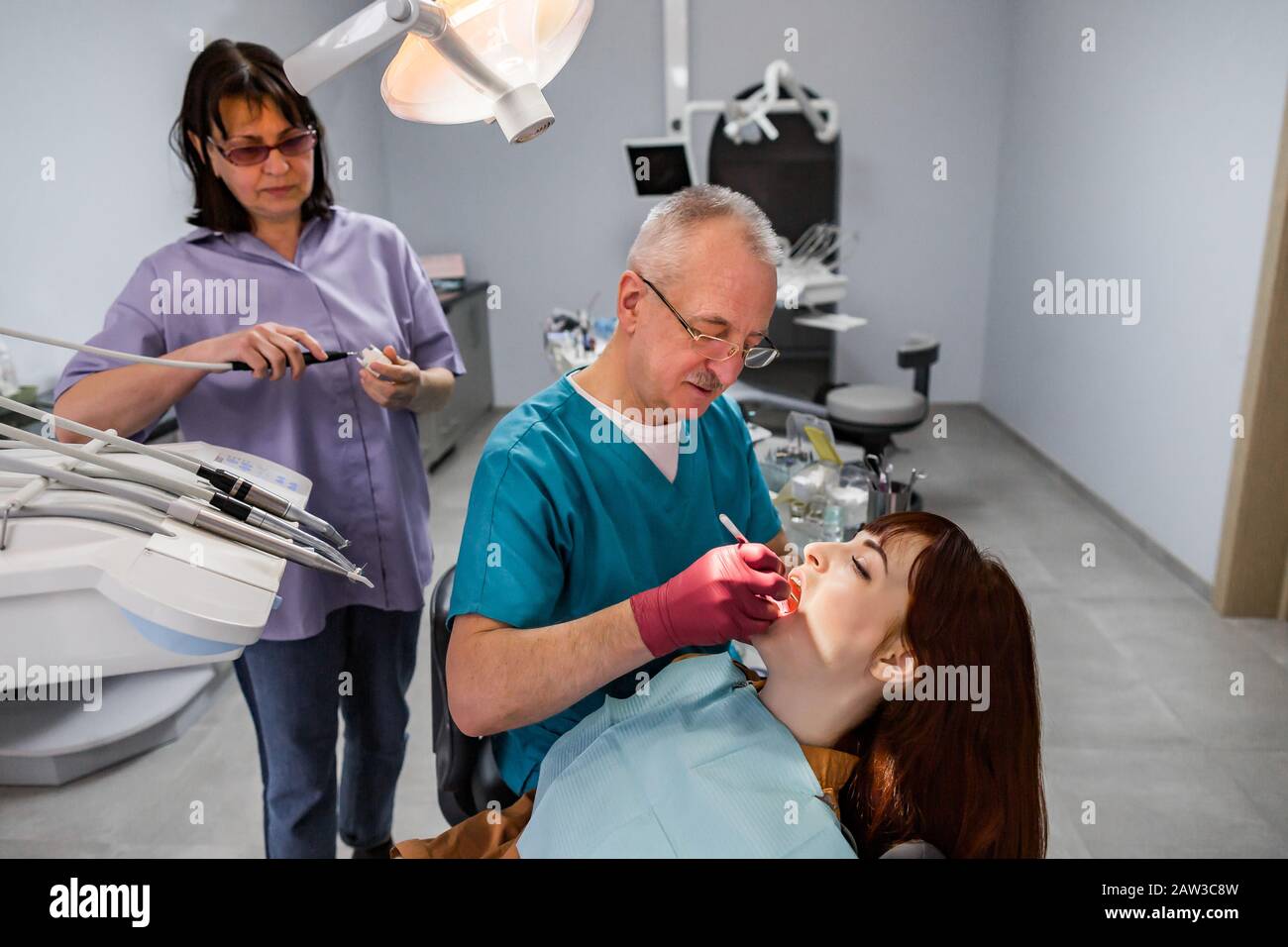 Dentist team, elderly man and woman, and young female patient having