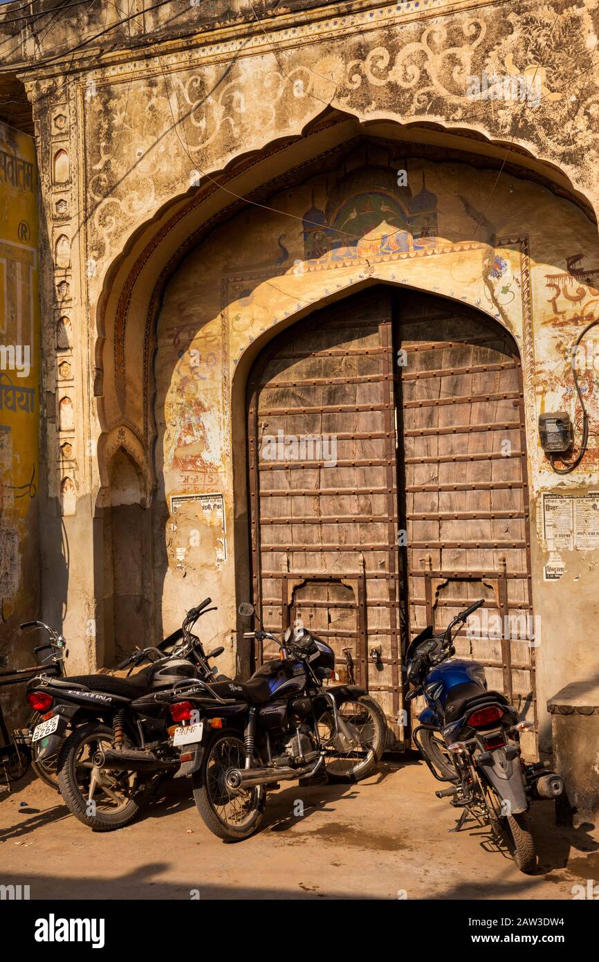 India, Rajasthan, Shekhawati, Mandawa, motorcycles parked outside historic wooden haveli gate Stock Photo