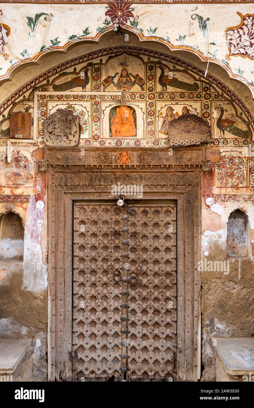 India, Rajasthan, Shekhawati, Mandawa, Binsidhar Newatia Haveli, painted decoration surrounding, old door made from small wooden pieces Stock Photo
