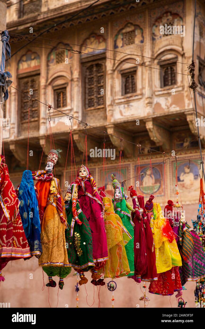 India, Rajasthan, Shekhawati, Mandawa, tourist souvenir puppets for sale outside decorated haveli being restored as heritage hotel Stock Photo
