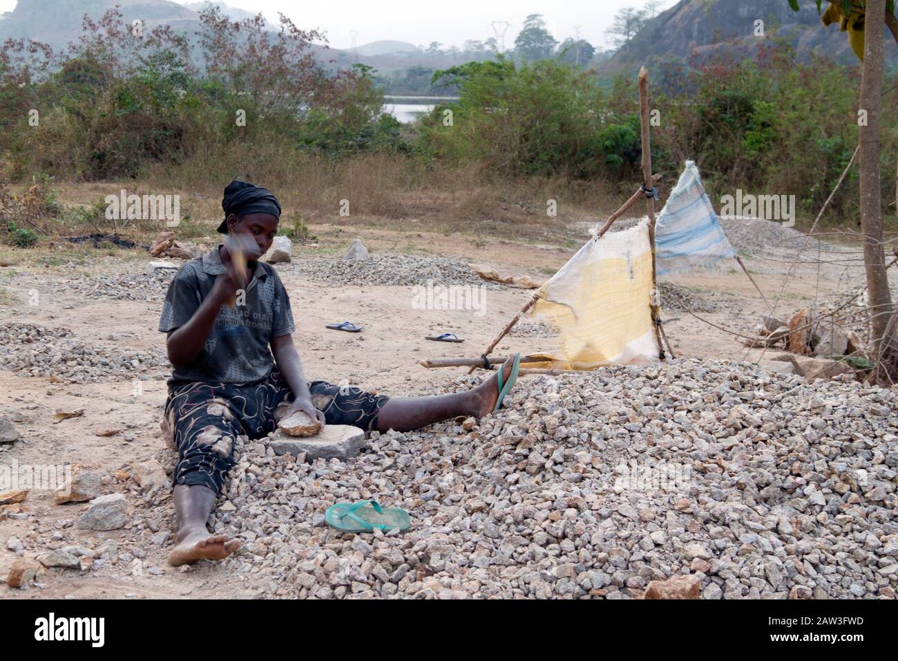 Adolescents crushing stones in a stone quarry near Duékoué in Ivory Coast ,Africa Stock Photo