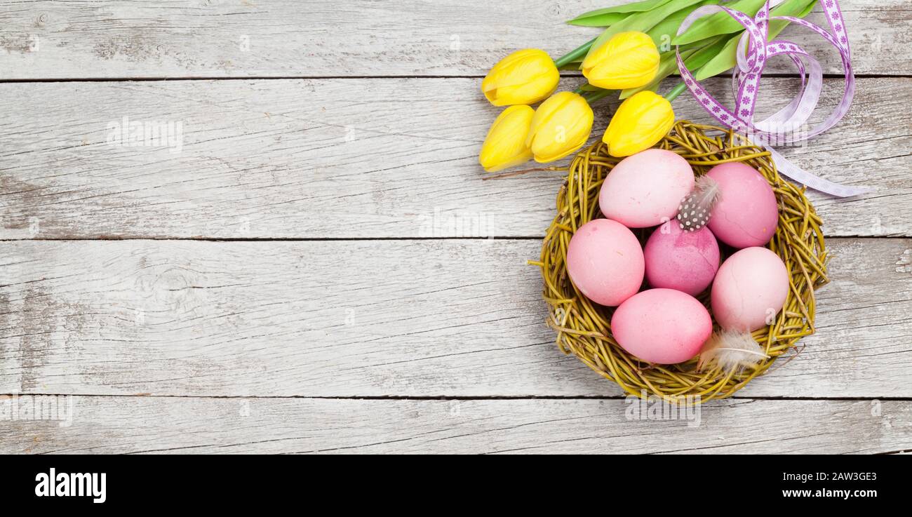 Easter greeting card with easter eggs and tulip flowers over wooden ...