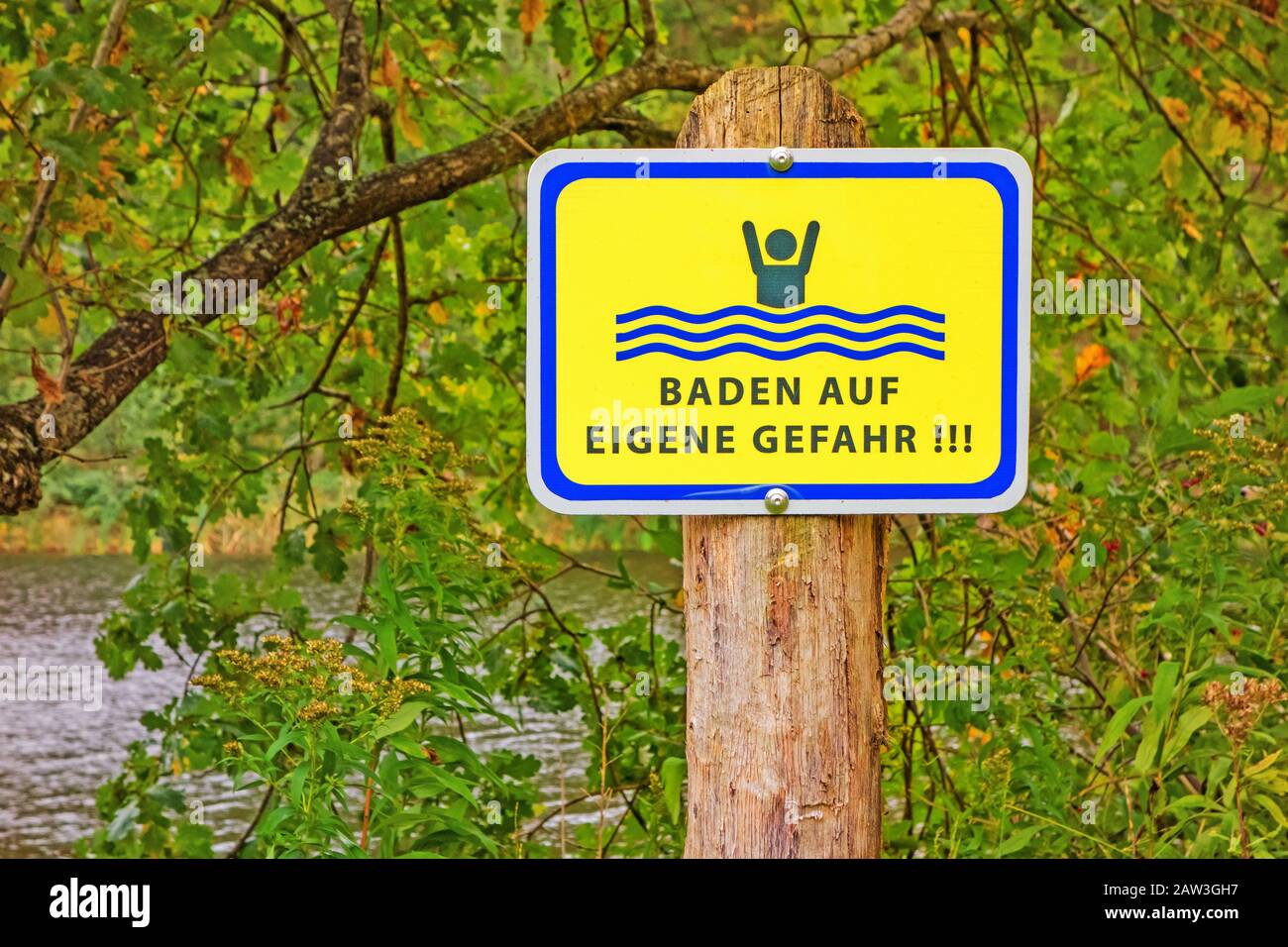 Sign at a lake labeled with Baden auf eigene Gefahr (swimming at own risk) Stock Photo