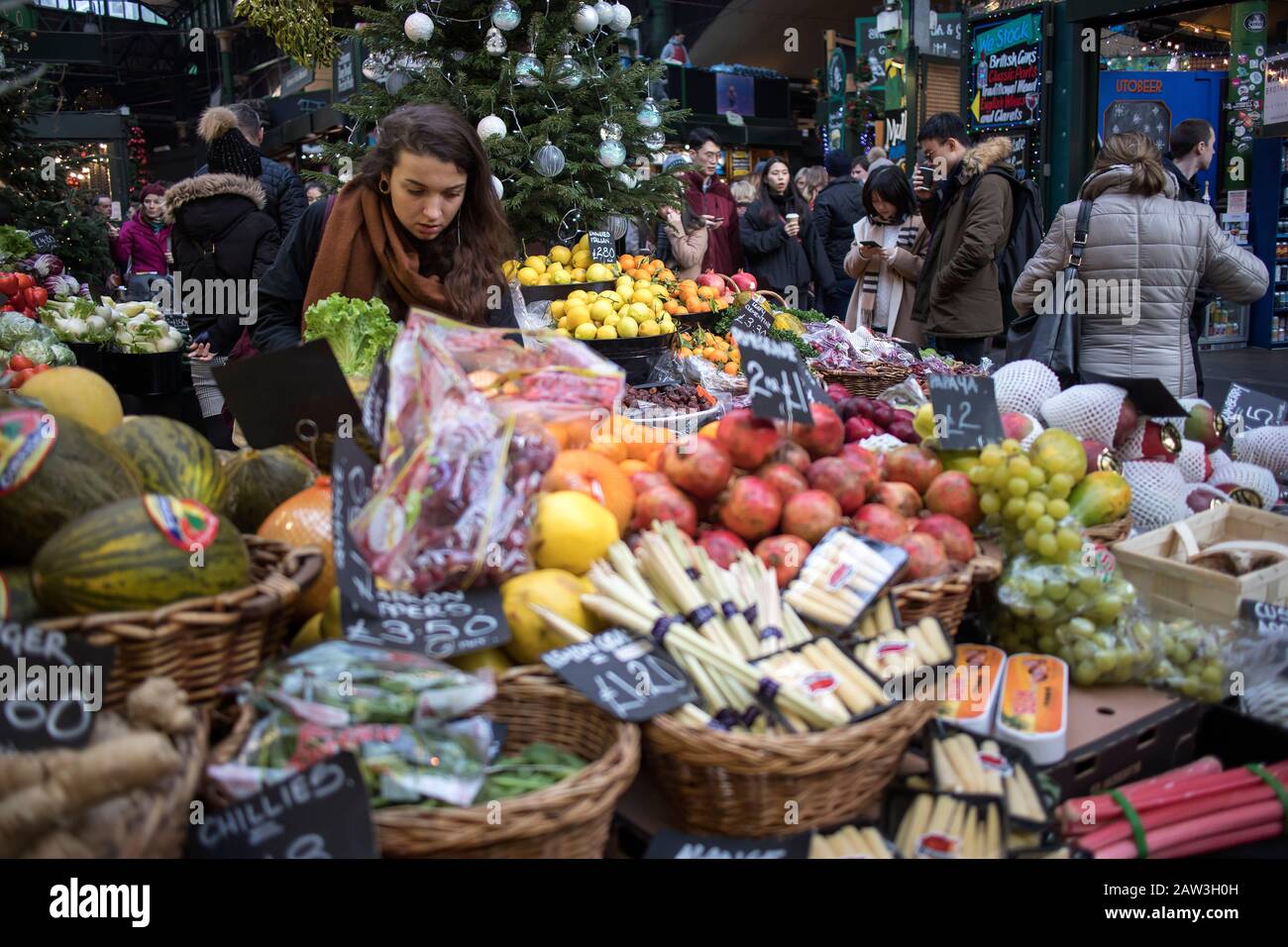 London, UK, - 23 - December 2019, Different types of vegetables and salads on the counter at Borough Market. Interior of a vegetable shop. Customer lo Stock Photo