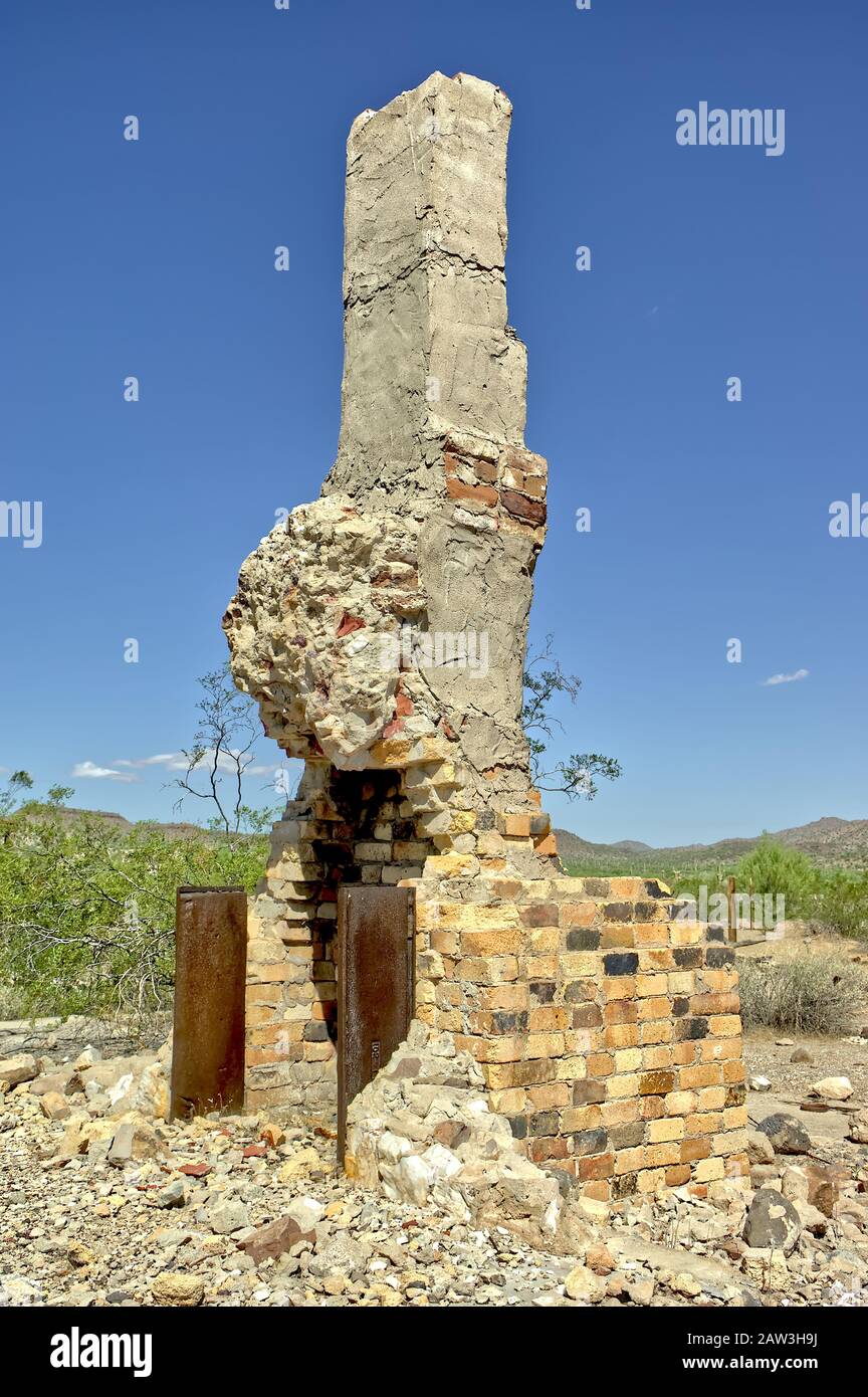 The ghostly remains of an old chimney from a home that burned down long ago in the ghost town of Freeman Arizona. Stock Photo