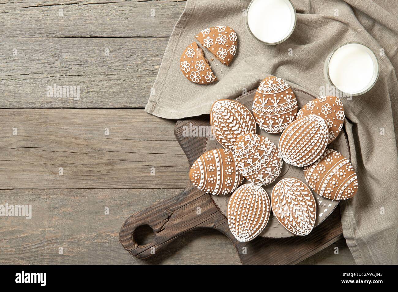 beautiful easter cookies on a plate, a glass of milk. On old wooden background Stock Photo