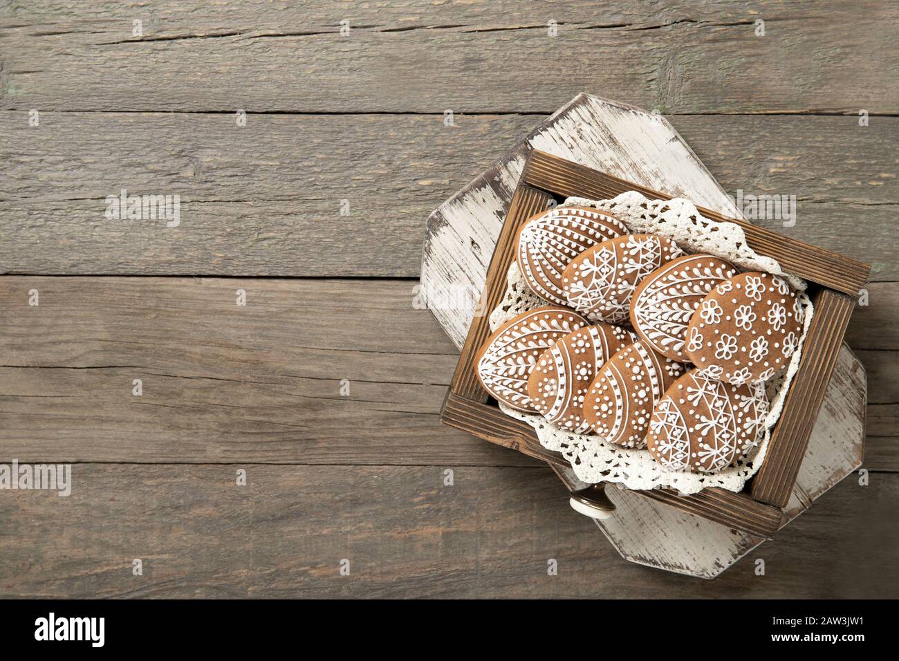 Easter cookies in a box on an old wooden background. Place for text. Easter eggs. Stock Photo