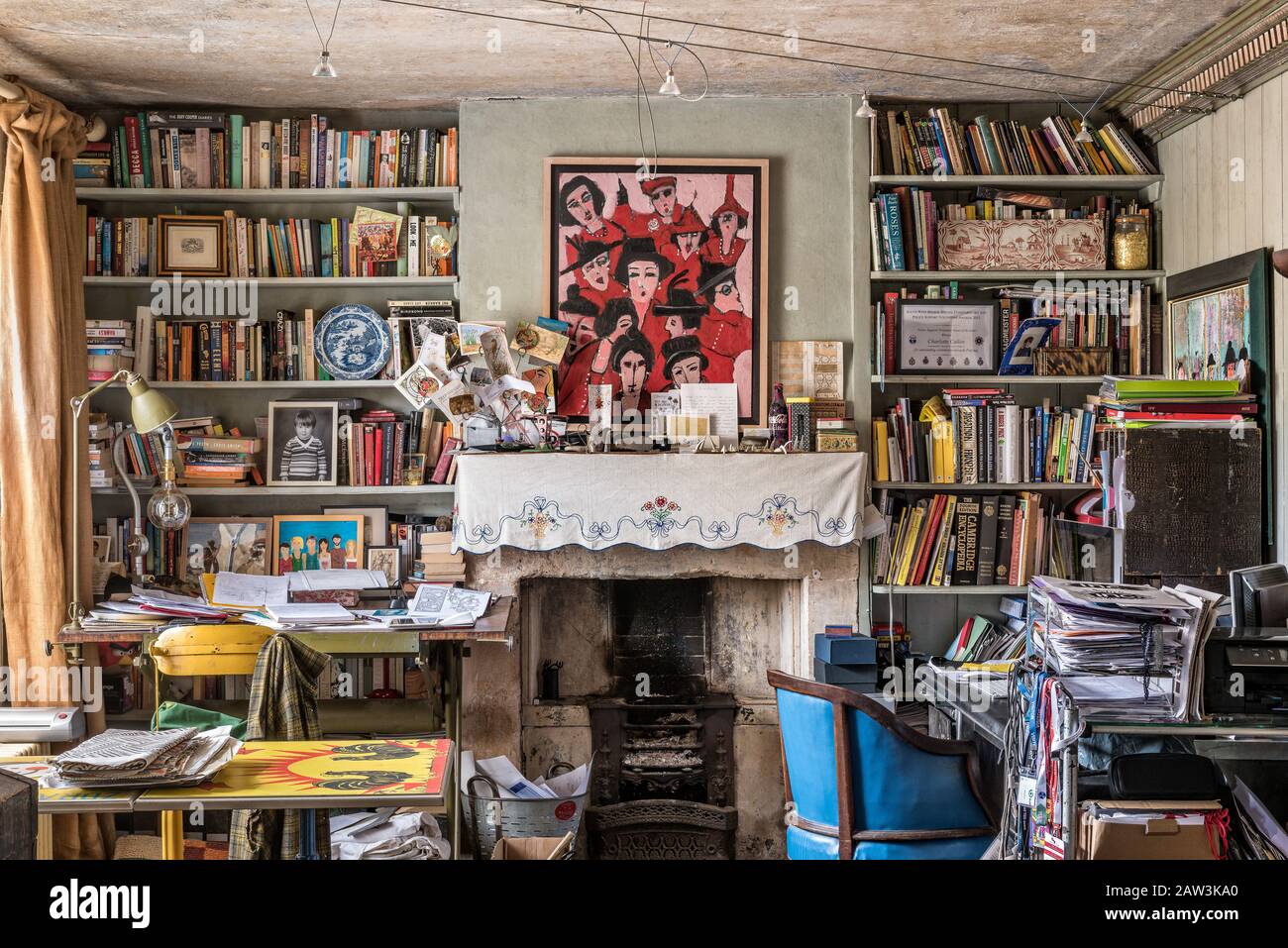 Cluttered room with bookcases and fireplace Stock Photo