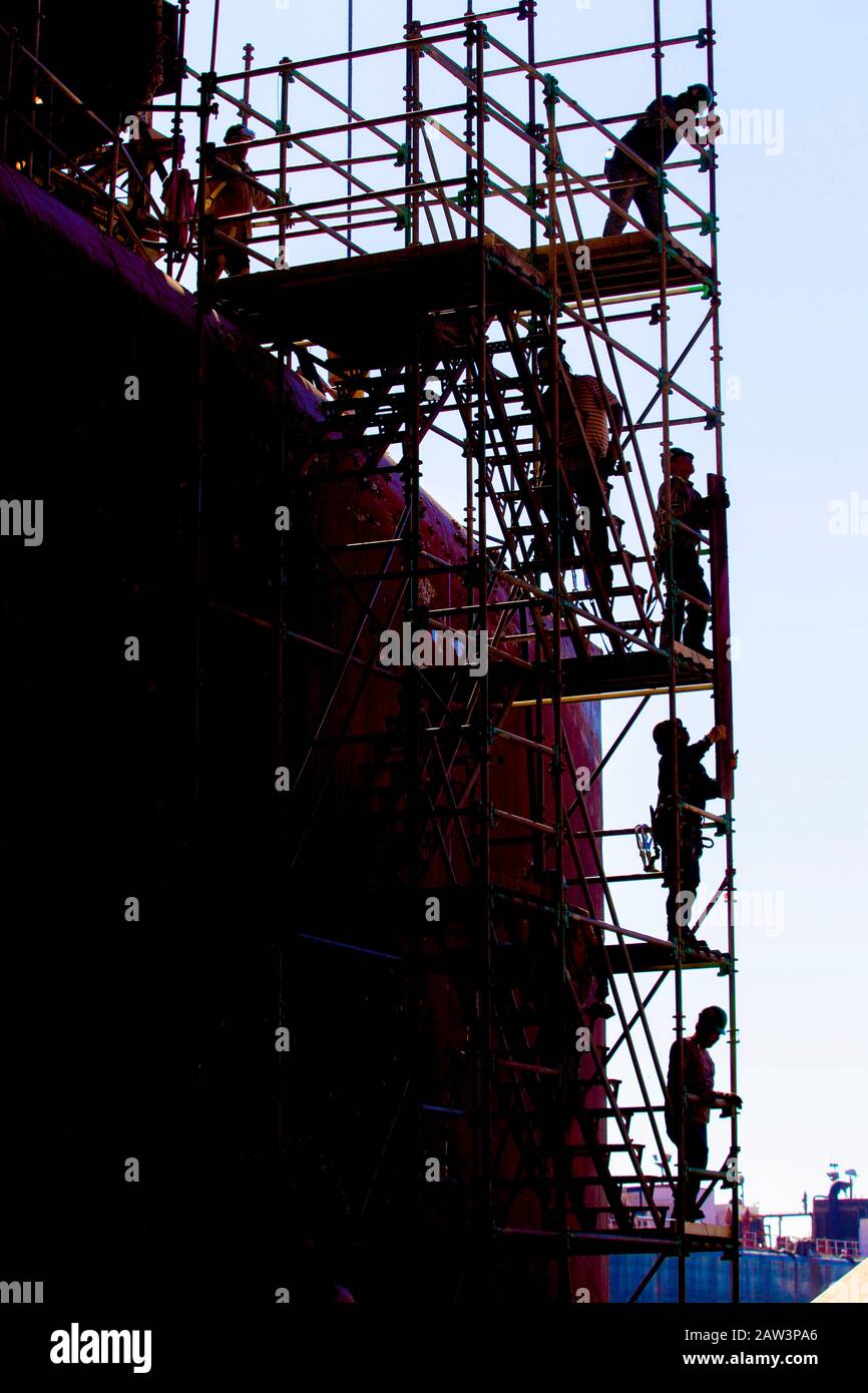 Shipyard maintenance workers working on scaffolding Stock Photo