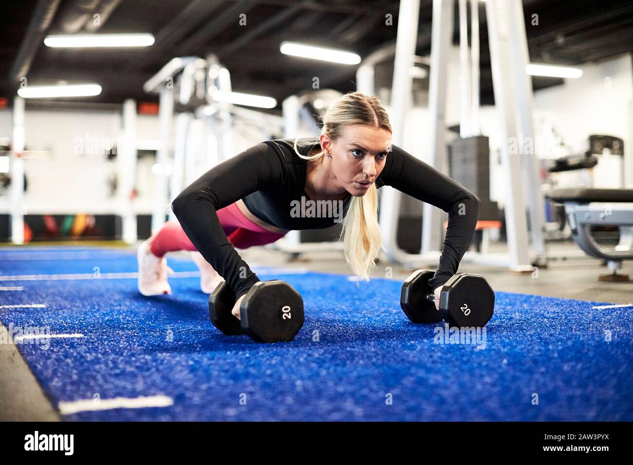 A woman doing push ups on the turf in the gym Stock Photo - Alamy