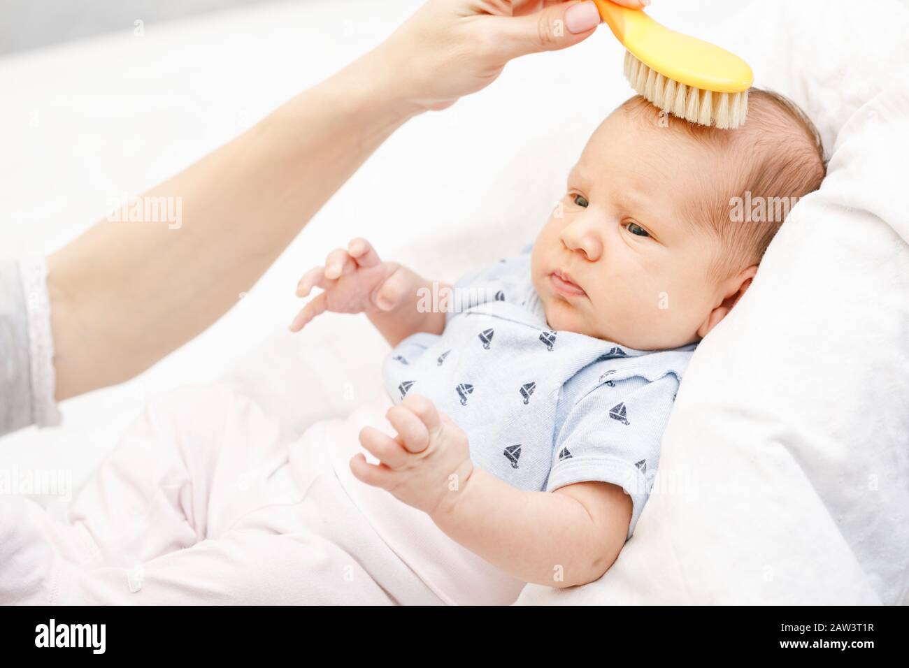 Mother brushing hair of her newborn baby using soft hairbrush to stimulate  infant's hair follicles and increase scalp blood flow for healthy hair grow  Stock Photo - Alamy