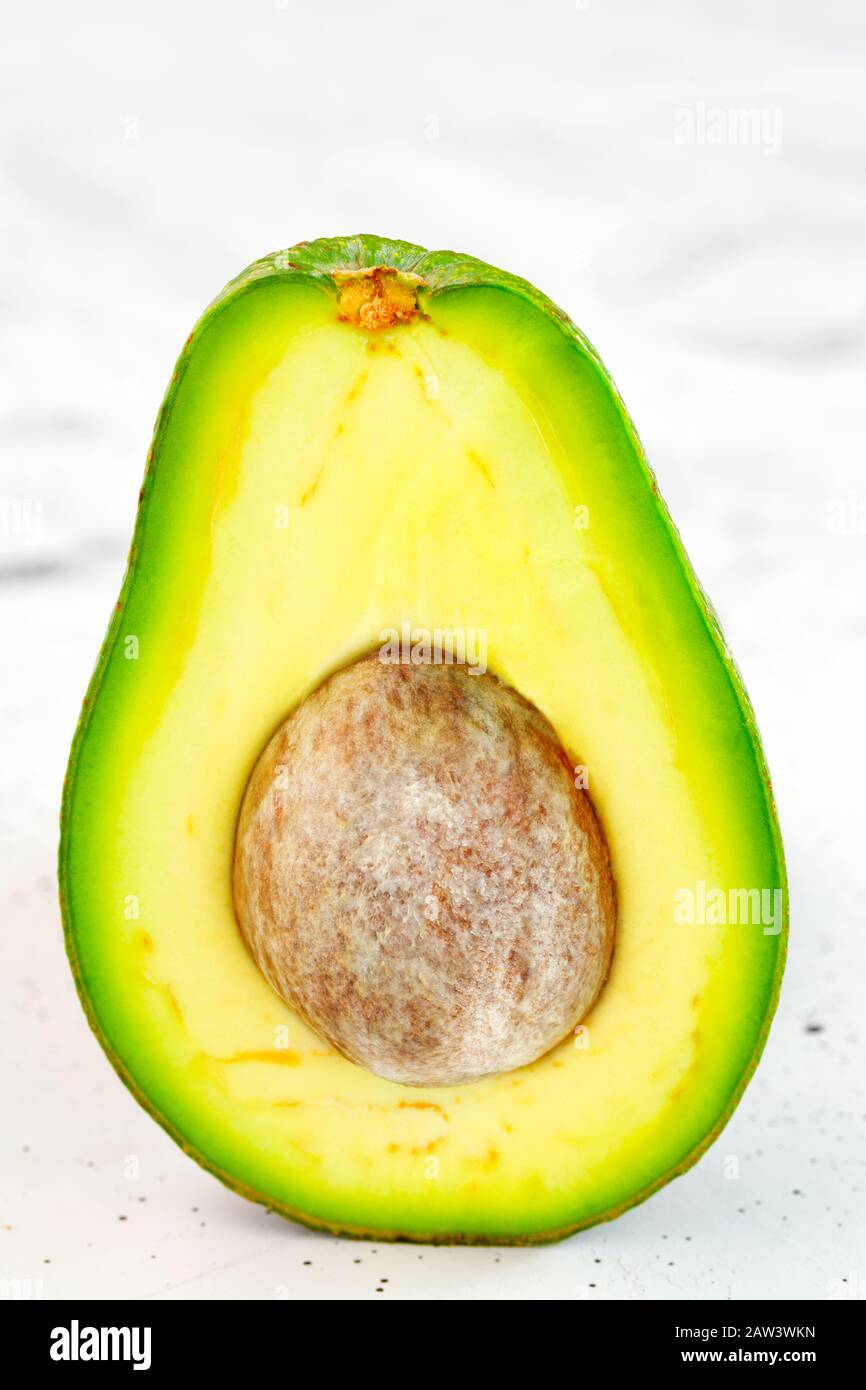 Avocado Cut In Half One Slice With Core On Gray Concrete Background Close Up Delicious And Nutritious Fruit Image With Copy Space Stock Photo Alamy