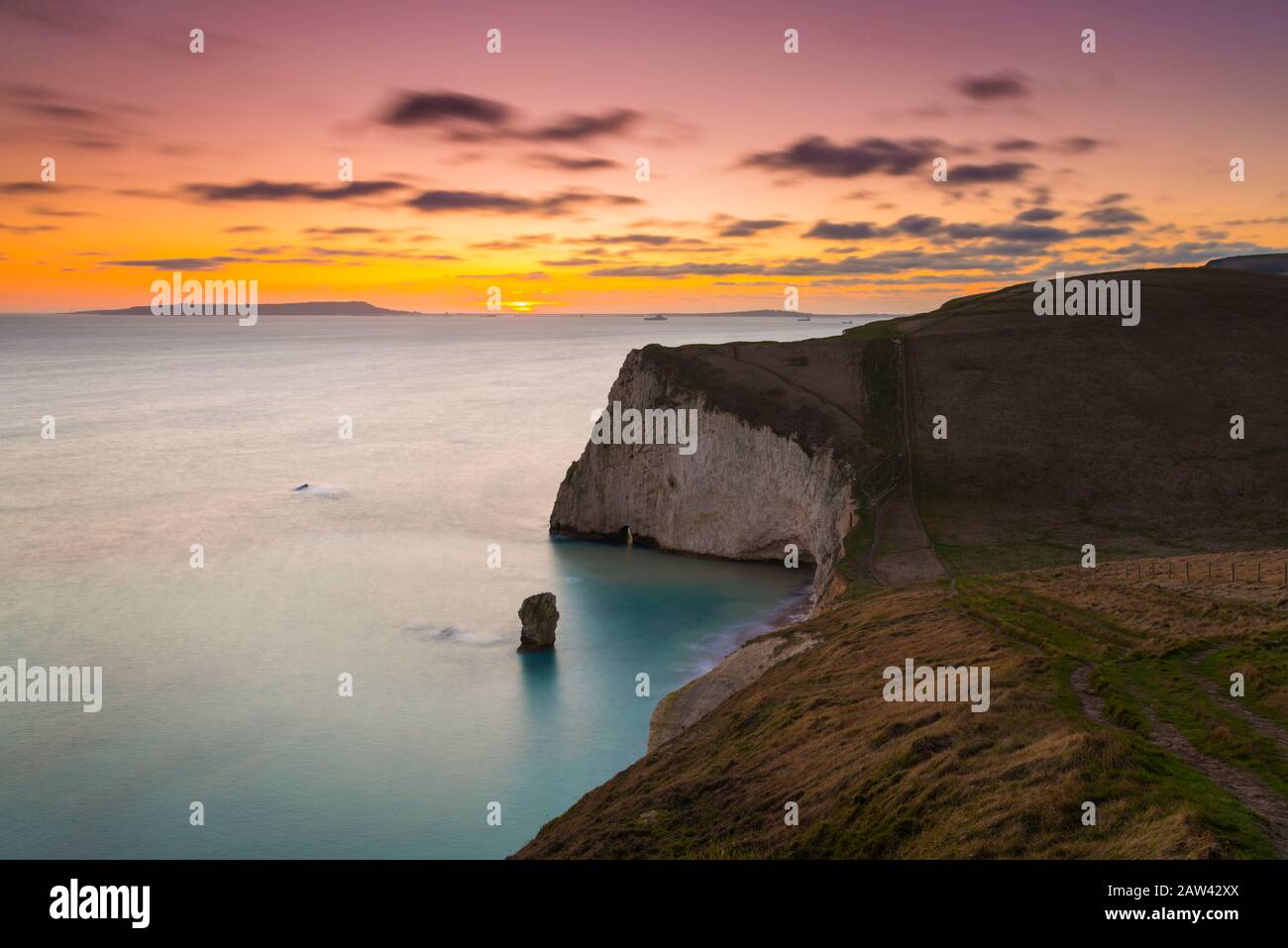 Lulworth, Dorset, UK.  6th February 2020. UK Weather.  A golden sunset at Bats Head near Lulworth in Dorset looking west towards Weymouth and the Isle of Portland viewed from the South West Coast Path on Swyre Head.  Picture Credit: Graham Hunt/Alamy Live News Stock Photo