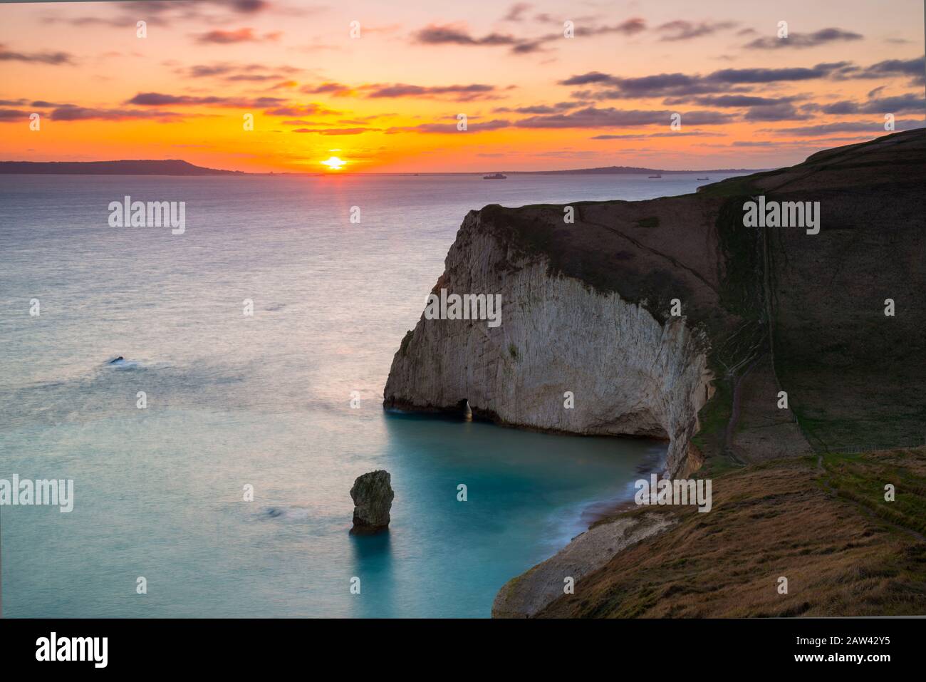 Lulworth, Dorset, UK.  6th February 2020. UK Weather.  A golden sunset at Bats Head near Lulworth in Dorset looking west towards Weymouth and the Isle of Portland viewed from the South West Coast Path on Swyre Head.  Picture Credit: Graham Hunt/Alamy Live News Stock Photo