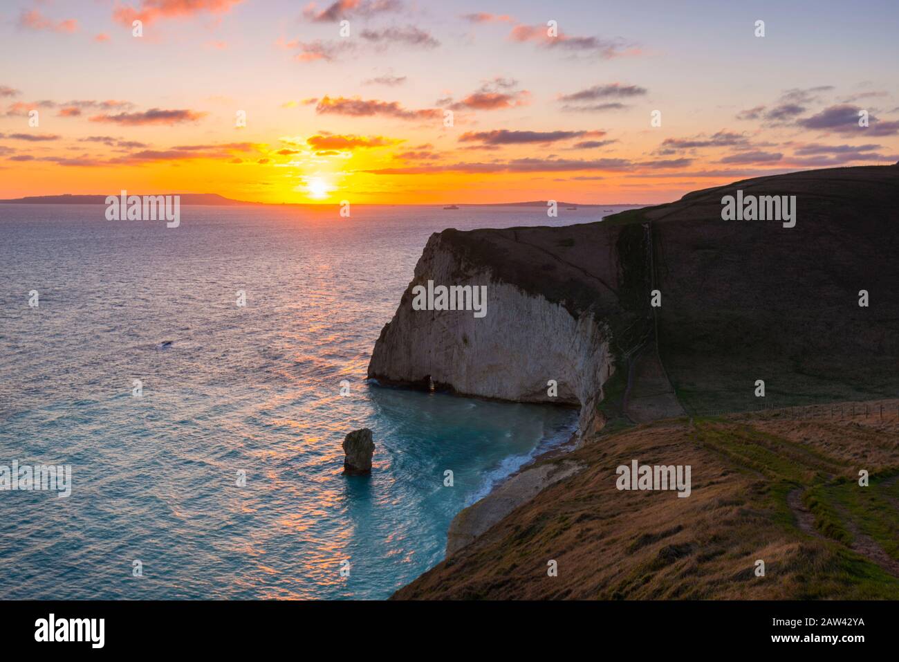 Lulworth, Dorset, UK.  6th February 2020. UK Weather.  A golden sunset at Bats Head near Lulworth in Dorset looking west towards Weymouth and the Isle of Portland viewed from the South West Coast Path on Swyre Head.  Picture Credit: Graham Hunt/Alamy Live News Stock Photo