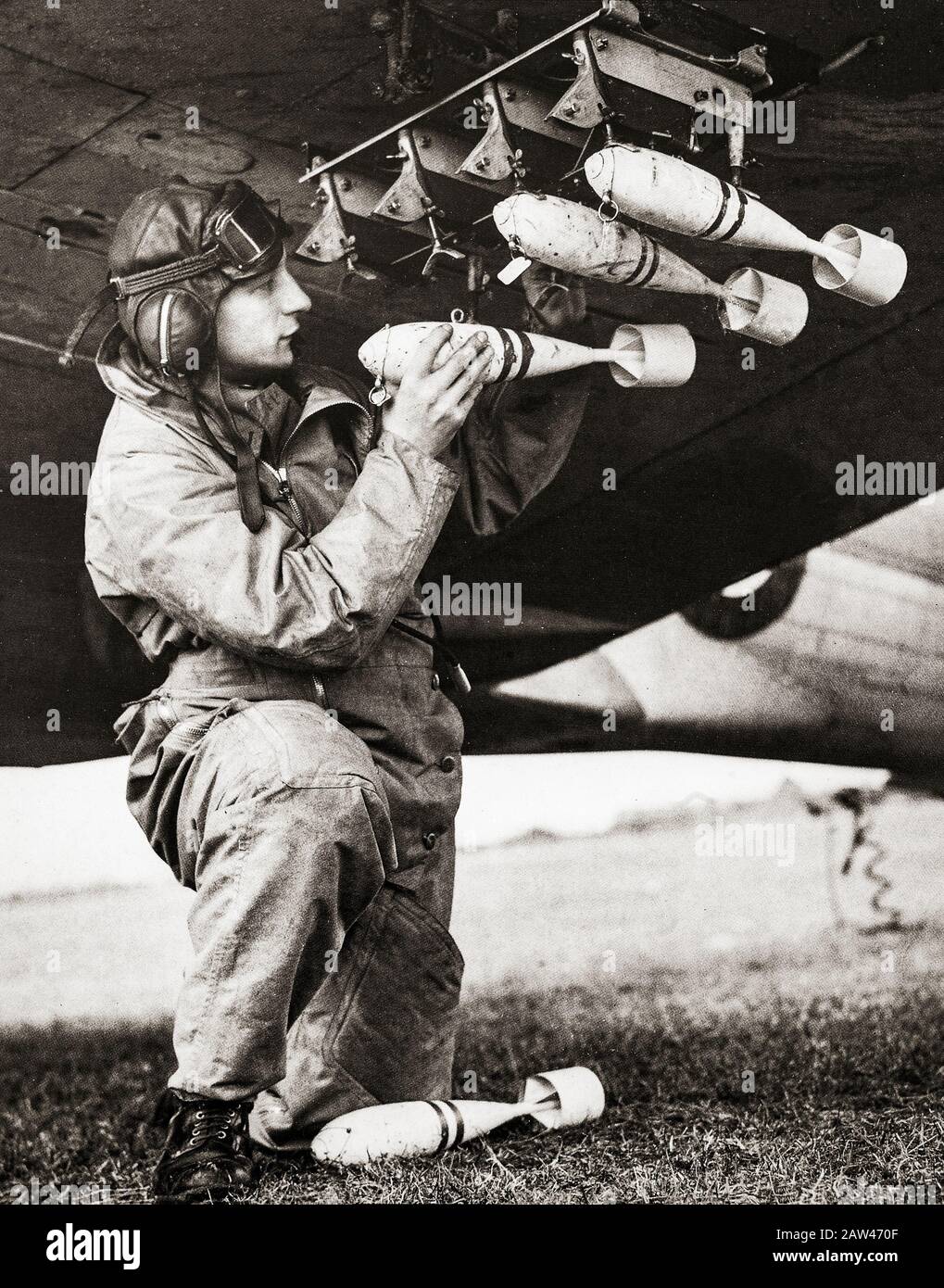 1940: Loading practice bombs that explode with a small puff of smoke enabling observers to see the results of the pilots efforts. Stock Photo