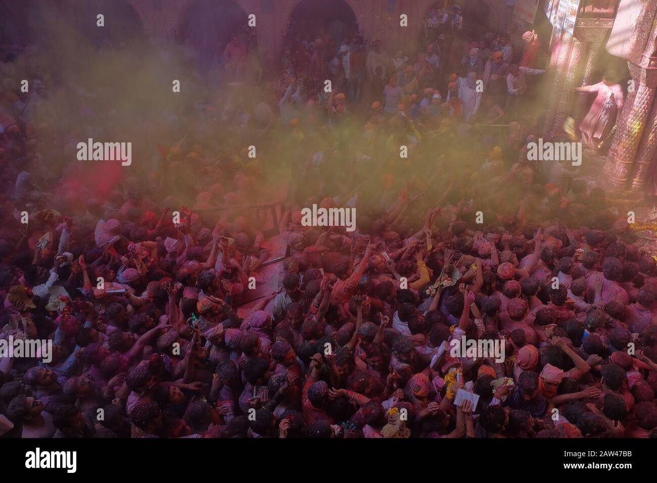 General view crowded during the Hindu Holi Festival in banke bihari temple vrindavan, India, on March 20, 2019. The Hindu Holi Festival takes place in India. The two-day celebration marks the victory of good over evil and marks the end of winter and the arrival of spring. Holi Festival celebrations are usually Indian residents playing water while throwing colorful powder. Stock Photo