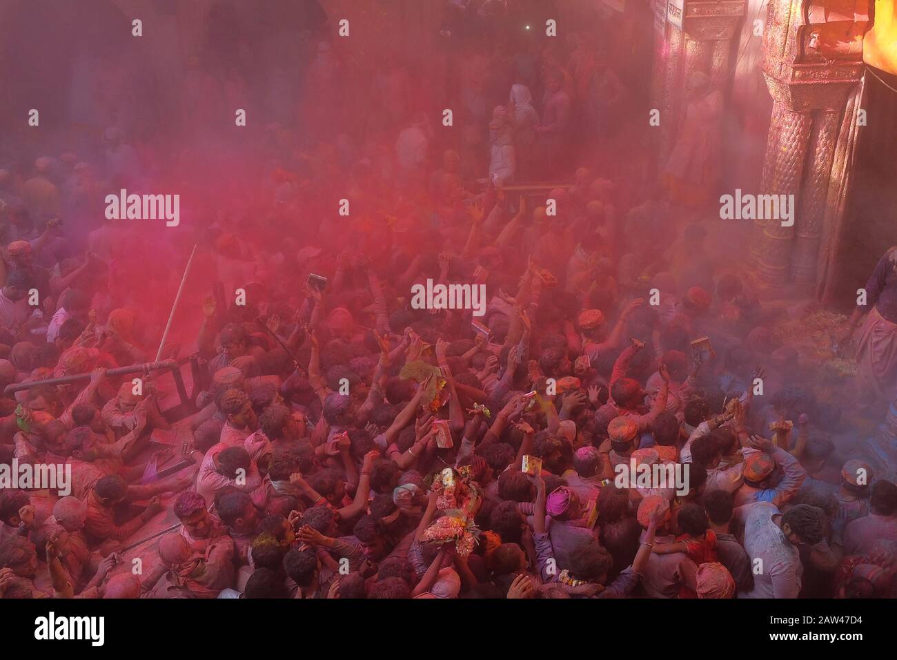 General view crowded during the Hindu Holi Festival in banke bihari temple vrindavan, India, on March 20, 2019. The Hindu Holi Festival takes place in India. The two-day celebration marks the victory of good over evil and marks the end of winter and the arrival of spring. Holi Festival celebrations are usually Indian residents playing water while throwing colorful powder. Stock Photo