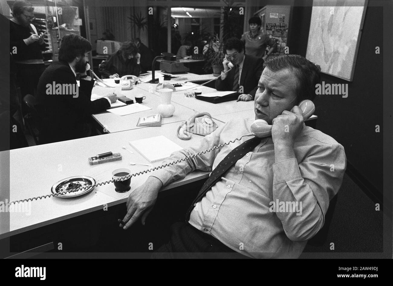 PvdA top members answered the phone at office party PvdA in Amsterdam. Max van der Berg, Ed van Thijn and Van Dam minister on the phone Annotation: In the background Hedy d'Ancona Date: March 11, 1982 Location: Amsterdam, Noord-Holland Keywords: ministers, political parties Person Name: Ancona, Hedy d ' Berg, Max van den Dam, Marcel, Thijn, Ed van Stock Photo
