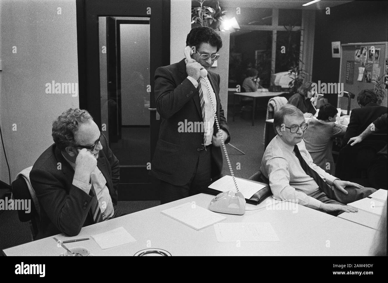 PvdA top members answered the phone at office party PvdA in Amsterdam. From left to right. Minister Kemenade, Ed van Thijn and Wim Meijer Date: March 11, 1982 Location: Amsterdam, Noord-Holland Keywords: ministers, political parties Person Name: Kemenade, Jos, Meijer, Wim, Thijn, Ed van Stock Photo