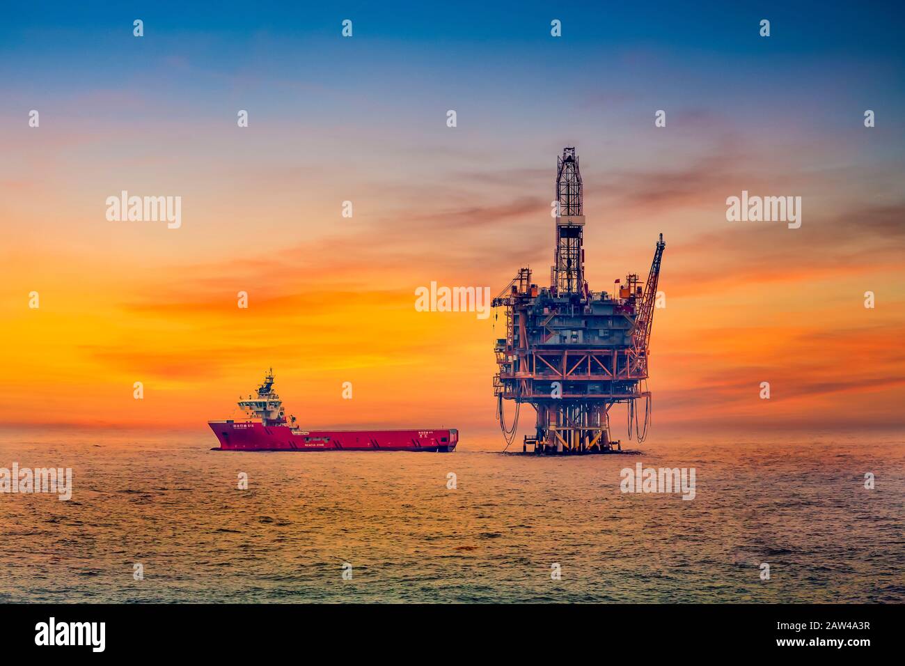 An ocean oil rig and supply ship in the South China Sea near Japan. Stock Photo