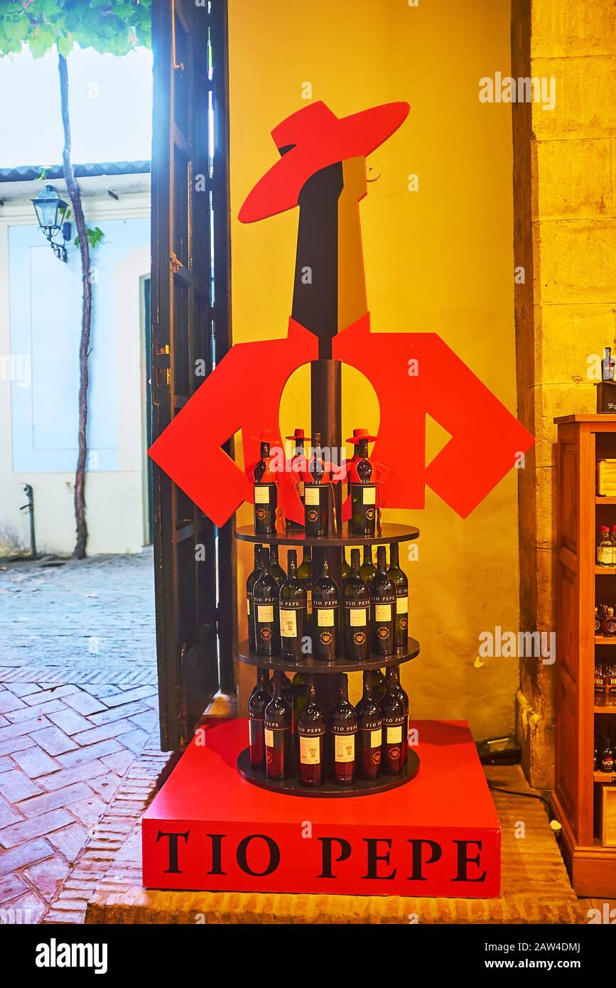 JEREZ, SPAIN - SEPTEMBER 20, 2019: The colorful Tio Pepe brand stand, shaped as Sherry wine bottle in hat and jacket, located in shop of the winery, o Stock Photo