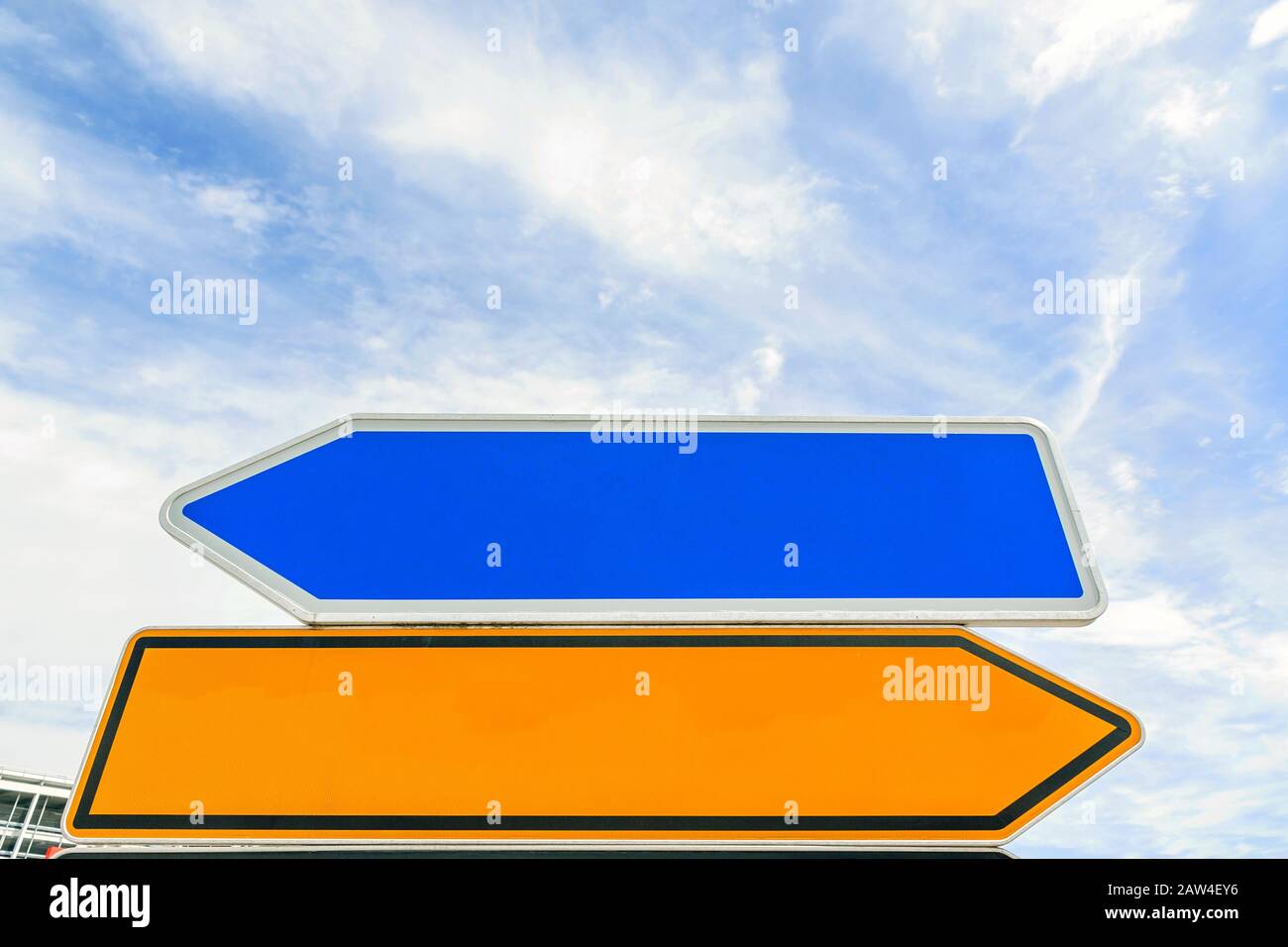 empty arrow traffic sign (bidirectional) pointing to different sides (left / right) - blue sky Stock Photo