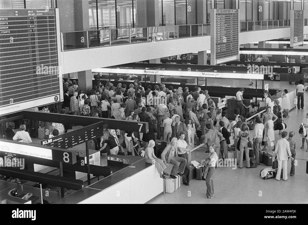 Holiday Bustle Schiphol  Travelers at the check-in date: July 11, 1975 Location: North-Holland, Schiphol Keywords: arrival and departure, travel, airports Institution Name: Parool, The Stock Photo