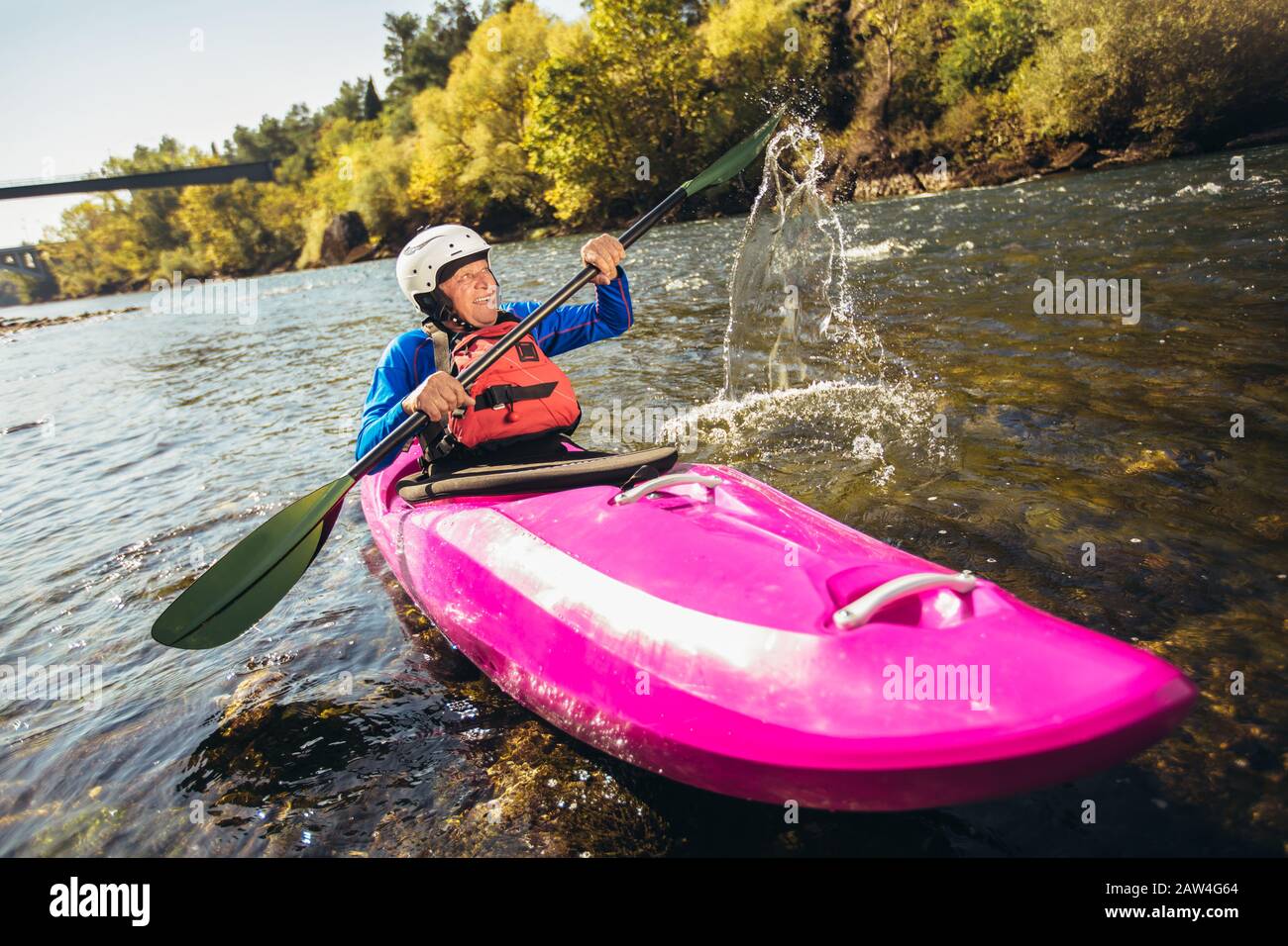 Active senior man paddling kayak. Gray hair man enjoy river kayaking. Stock Photo