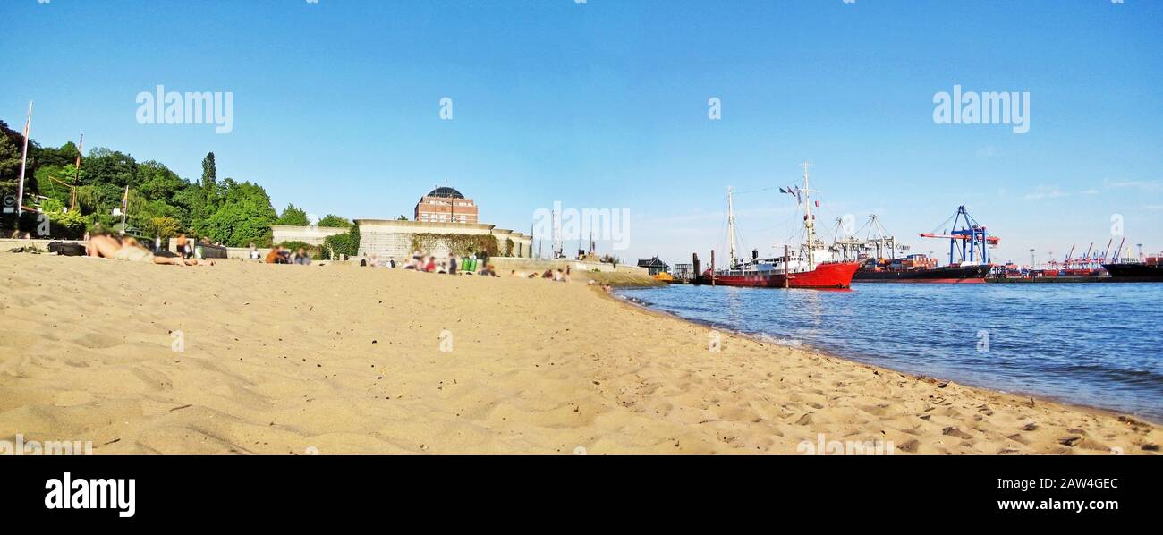 Hamburg, Germany - May 22, 2008: Hamburg city beach panorama (Stadtstrand) in Oevelgonne with sandy beach and harbor with ships and containers on the Stock Photo