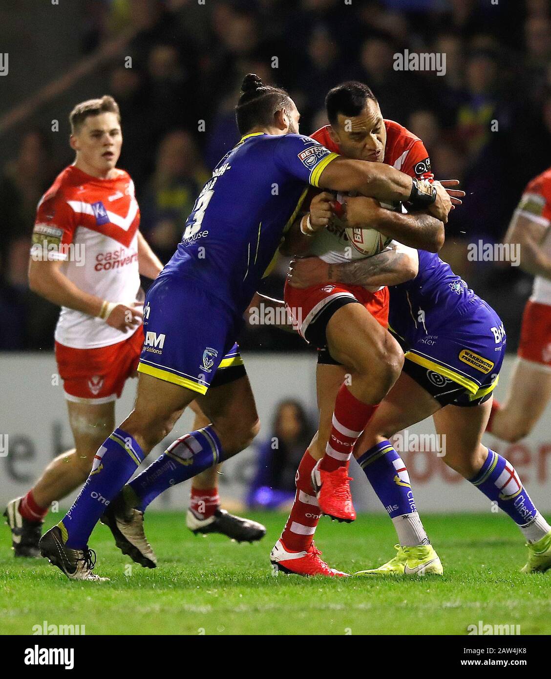 St Helens Saints' Zeb Taia is tackled by Warrington Wolves' Ben Murdock-Masila (left) and Blake Austin (right) during the Betfred Super League match at The Halliwell Jones stadium, Warrington. Stock Photo