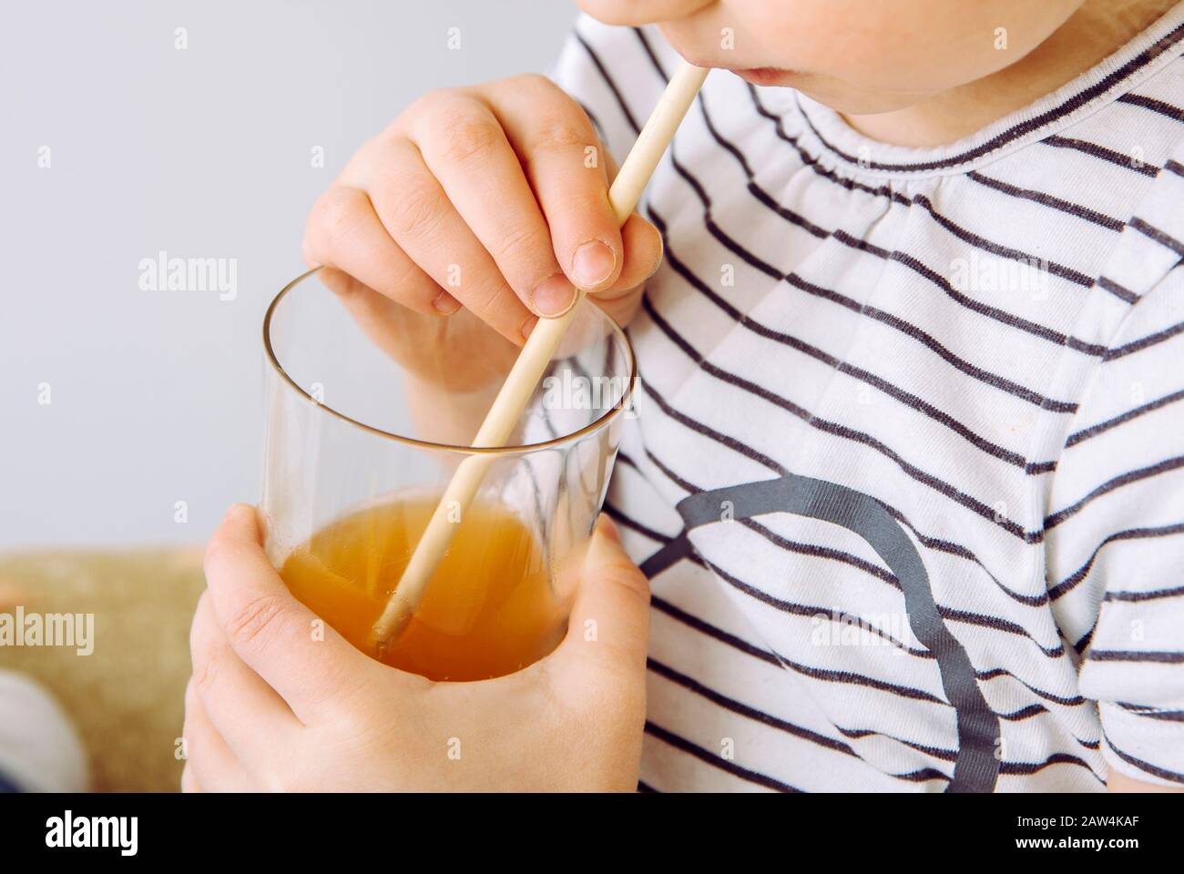 Close up view of girl child party drinking mixed juice with natural biodegradable bamboo straw. Plastic free lifestyle concept. Stock Photo