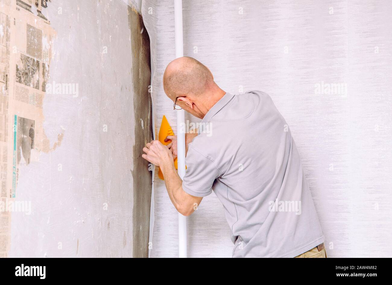 Adhesive Wallpaper Glue Applying Using Roller Close Up Photo. Worker  Installing New Modern Vinyl Wallpapers Stock Photo - Alamy