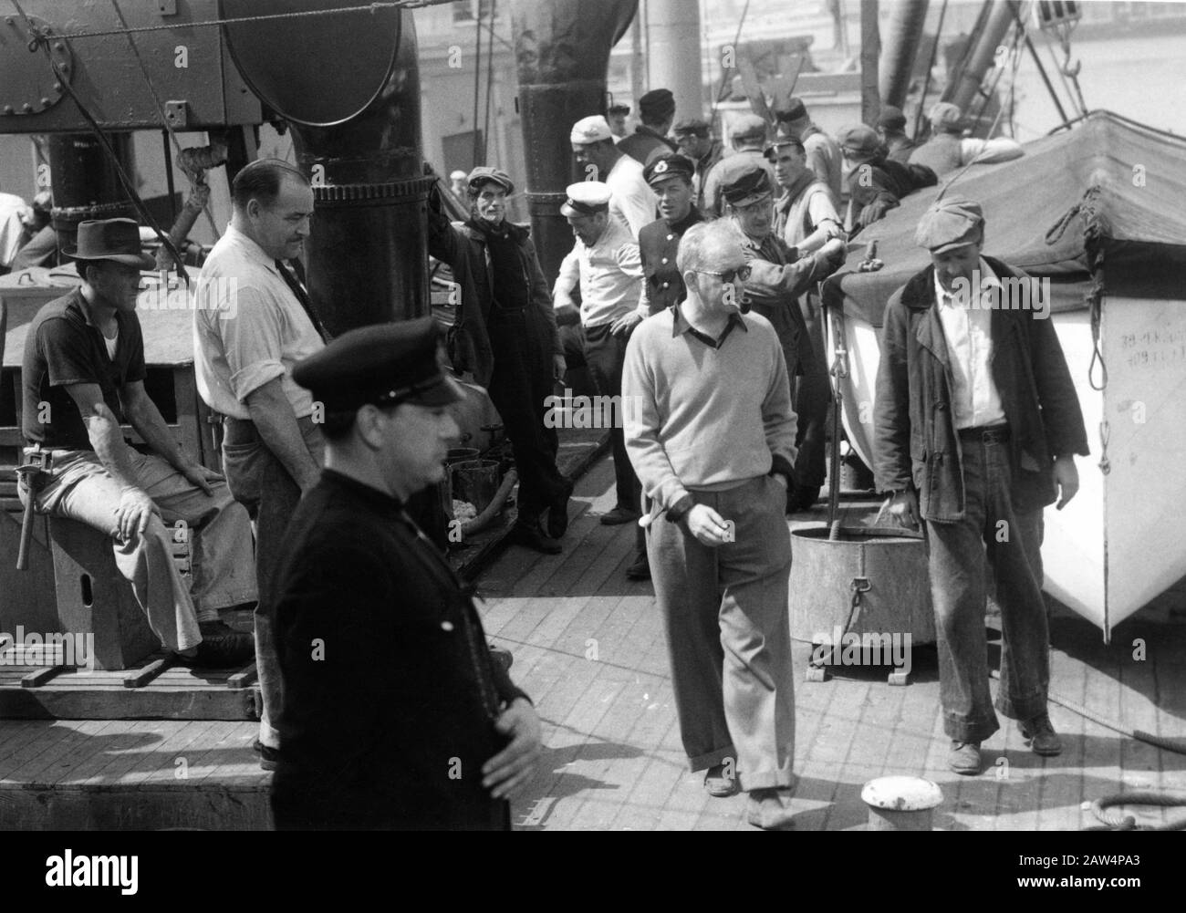 Assistant Director WINGATE SMITH (in white shirt with rolled up sleeves