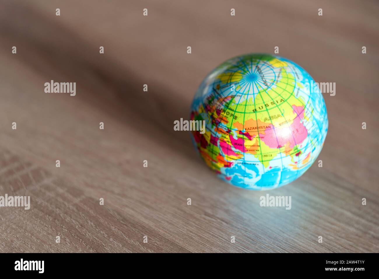 Asia continent on a small globe on a wooden surface Stock Photo