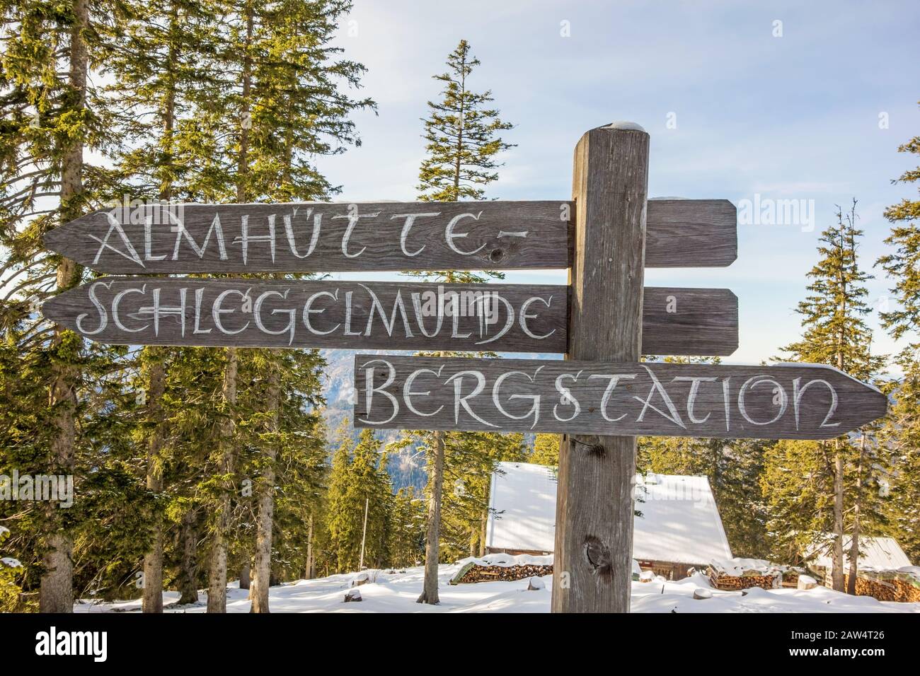 Mountain signpost showing the way to the alpine chalet ('Almhuette') and summit station ('Bergstation') in german language Stock Photo