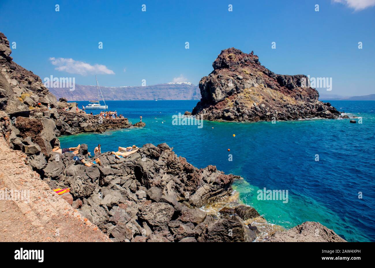 Oia, Santorini/ Greece 14JUL2019-Volcanic beach of Ammoudy Bay. Sisterhood of the traveling pants filming location. People tourists swimming and sunba Stock Photo