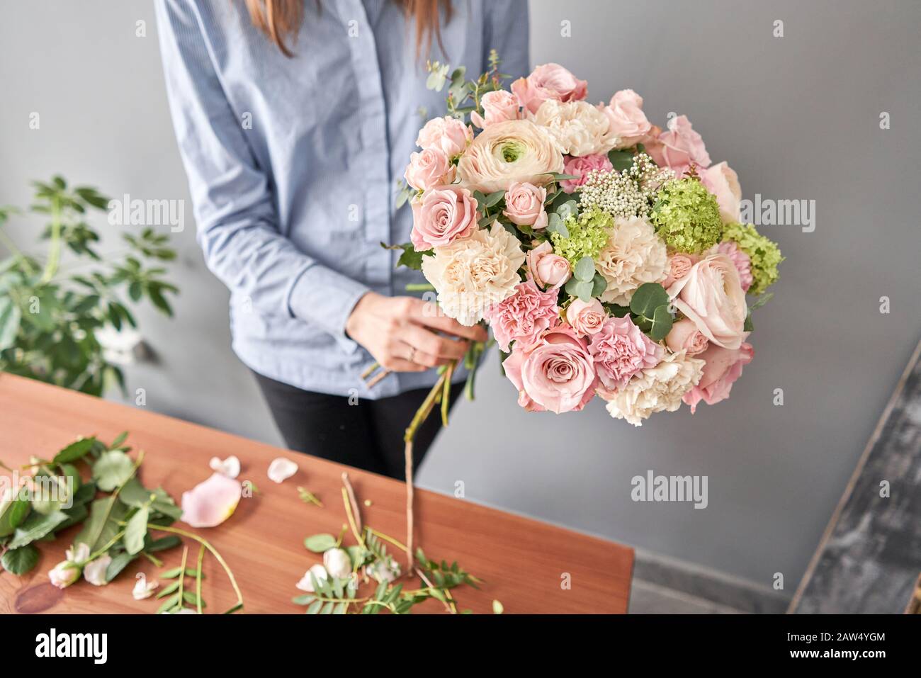 Woman florist creating beautiful bouquet in flower shop. Work in flower shop. Flowers delivery