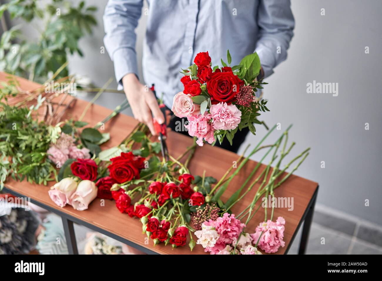 Woman florist creating beautiful bouquet in flower shop. Work in flower