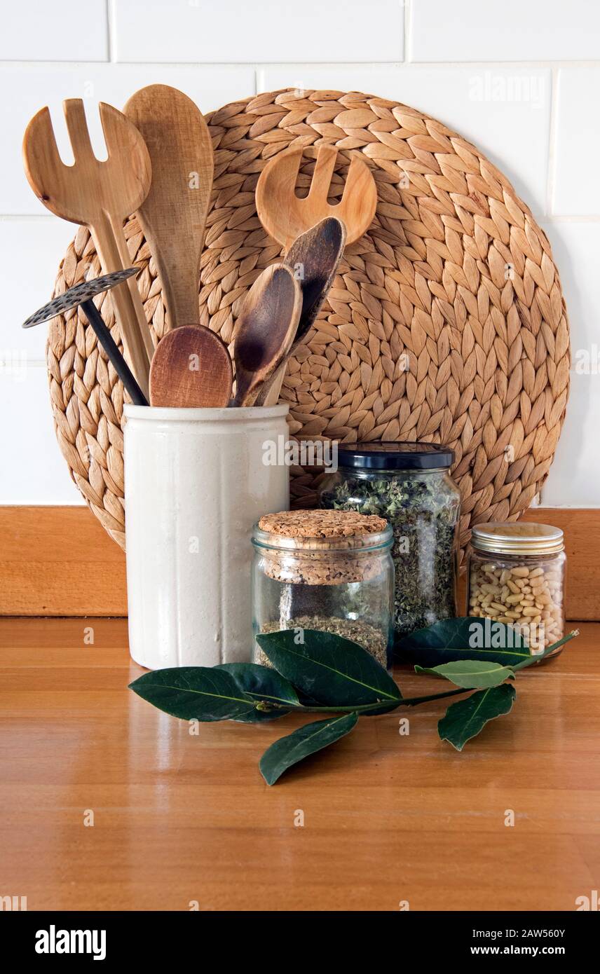 Eco friendly kitchen utensils with recycled glass storage jars against white tiles and Bay leaves in front, zero waste concept Stock Photo
