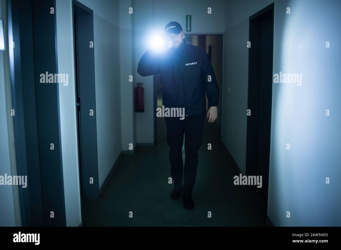 Security Guard With Flashlight Walking In Building Corridor Stock Photo ...