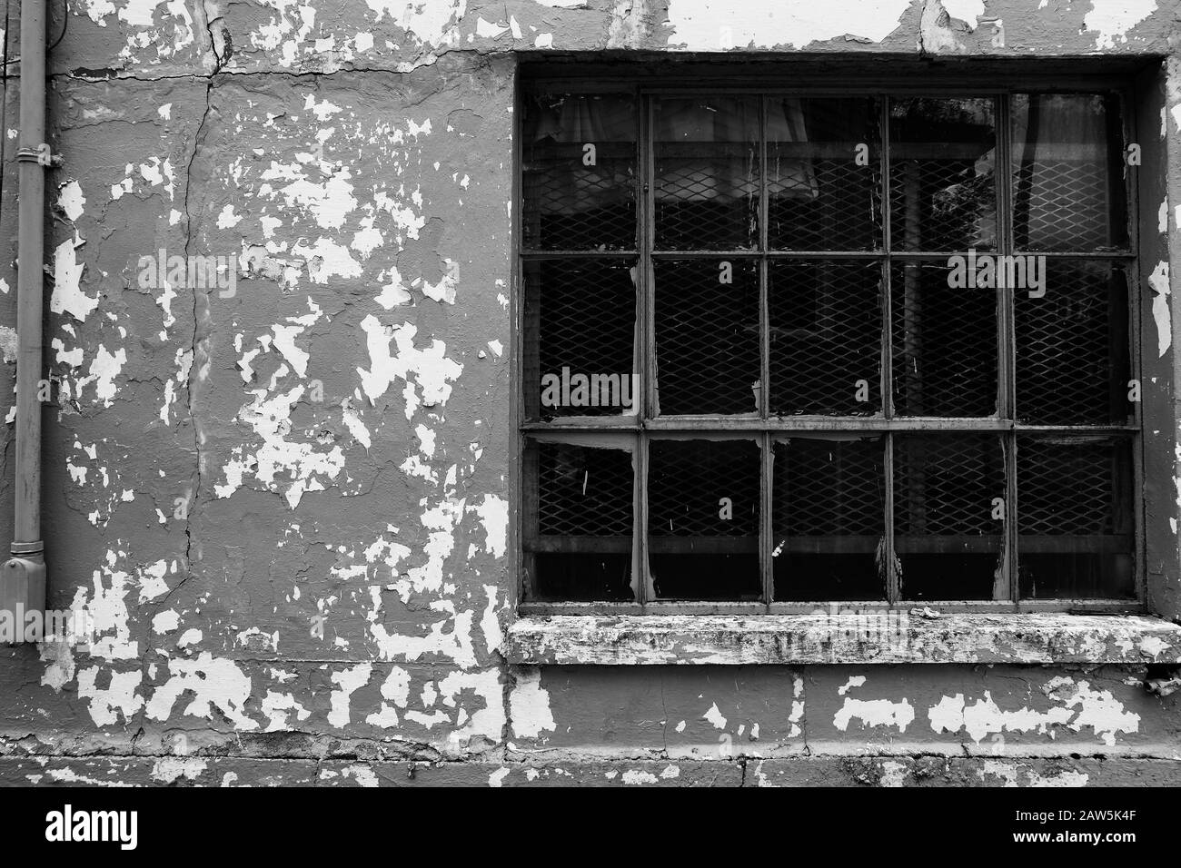 Peeling paint on an exterior wall near a window in the USA Stock Photo