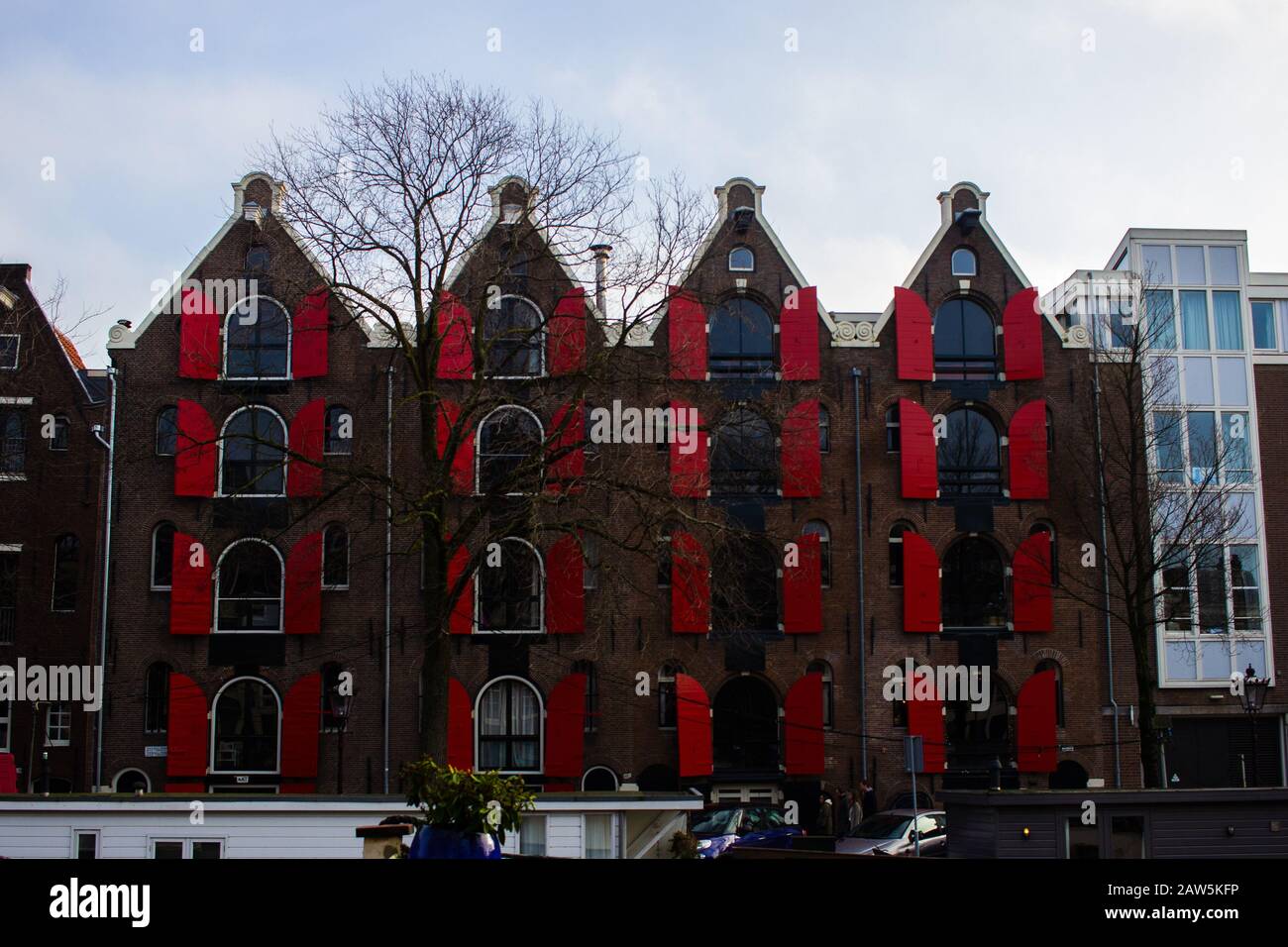 AMSTERDAM, NETHERLANDS - 26/1/20 - Vibrant red window shutters on a canal house Stock Photo