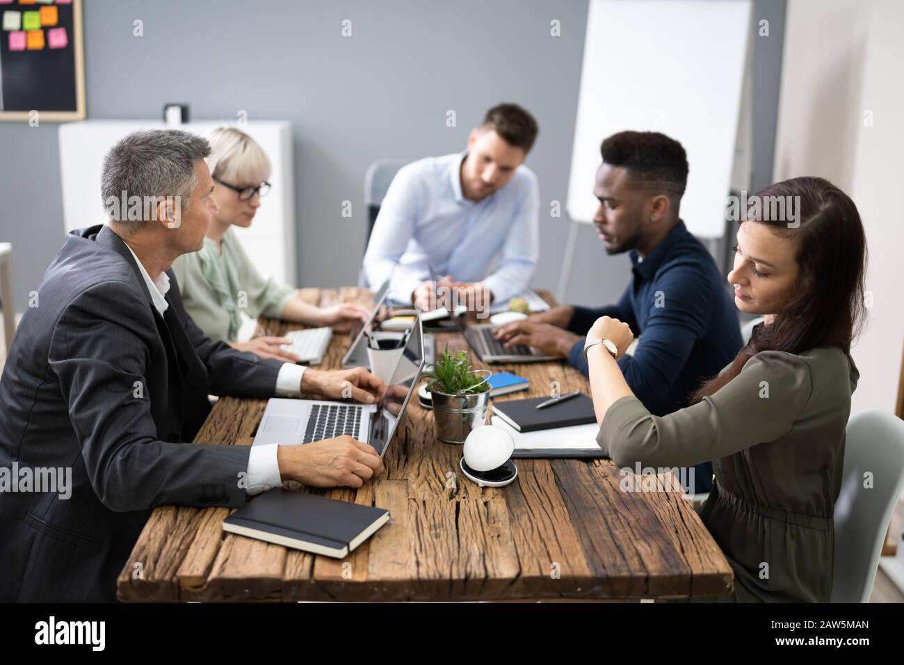 Woman Checking Time While Sitting In A Boring Long Meeting Stock Photo