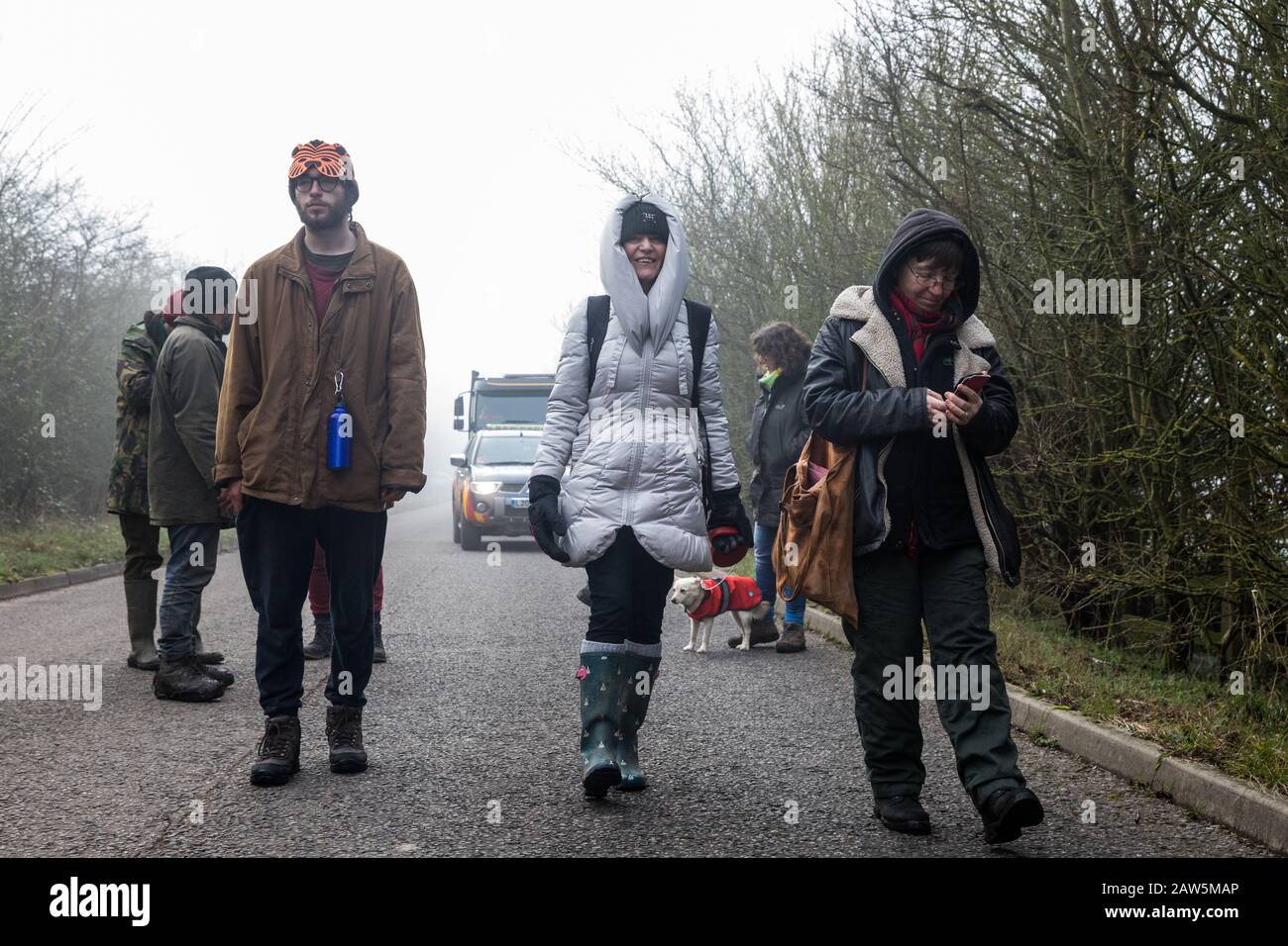 Denham, UK. 6 February, 2020. Environmental activists from Save the Colne Valley, Stop HS2 and Extinction Rebellion walk at a snail’s pace along a road in order to block a security vehicle and truck delivering fencing and other supplies to be used for works associated with the HS2 high-speed rail link close to the river Colne at Denham Ford. Works planned in the immediate vicinity include the felling of trees and the construction of a Bailey bridge, compounds and fencing, some of which in a wetland nature reserve forming part of a Site of Metropolitan Importance for Nature Conservation (SMI). Stock Photo
