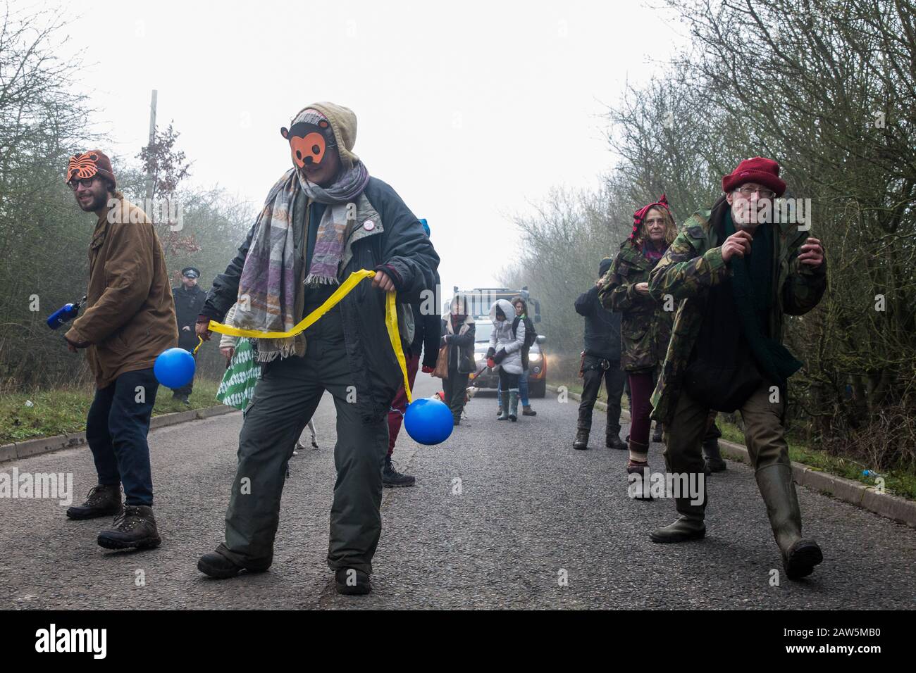 Denham, UK. 6 February, 2020. Environmental activists from Save the Colne Valley, Stop HS2 and Extinction Rebellion walk at a snail’s pace along a road so as to block for several hours a security vehicle and truck delivering fencing and other supplies to be used for works associated with the HS2 high-speed rail link close to the river Colne at Denham Ford. Works planned in the immediate vicinity include the felling of trees and the construction of a Bailey bridge, compounds and fencing, some of which in a wetland nature reserve forming part of a Site of Metropolitan Importance for Nature Conse Stock Photo