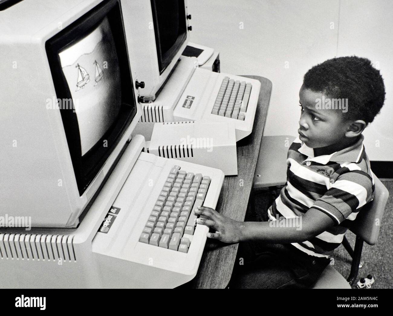 Austin, TX: 1980s. Preschool black boy using early Apple computer at daycare center.  © Bob Daemmrich Stock Photo