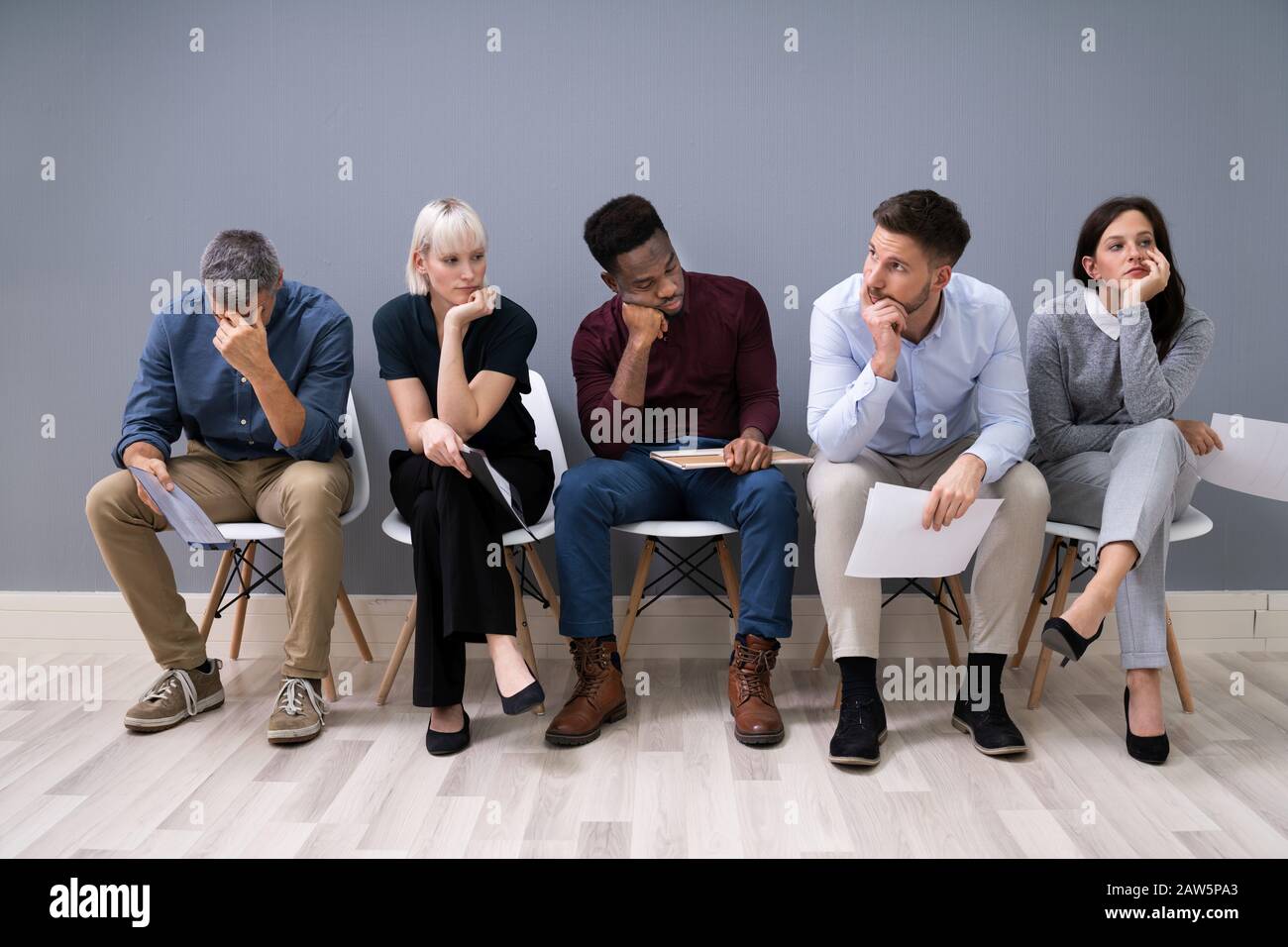 Business People Are Getting Bored While Sitting On Chair Waiting For Job Interview In Office Stock Photo