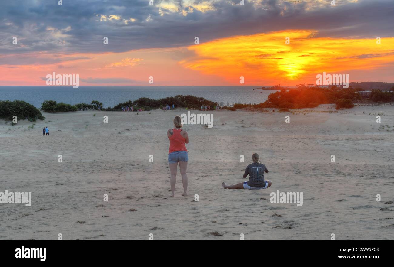 High dynamic range image of people watching the sunset over Albemarle Sound from Jockeys Ridge State Park in the town of Nags Head on the Outer Banks Stock Photo